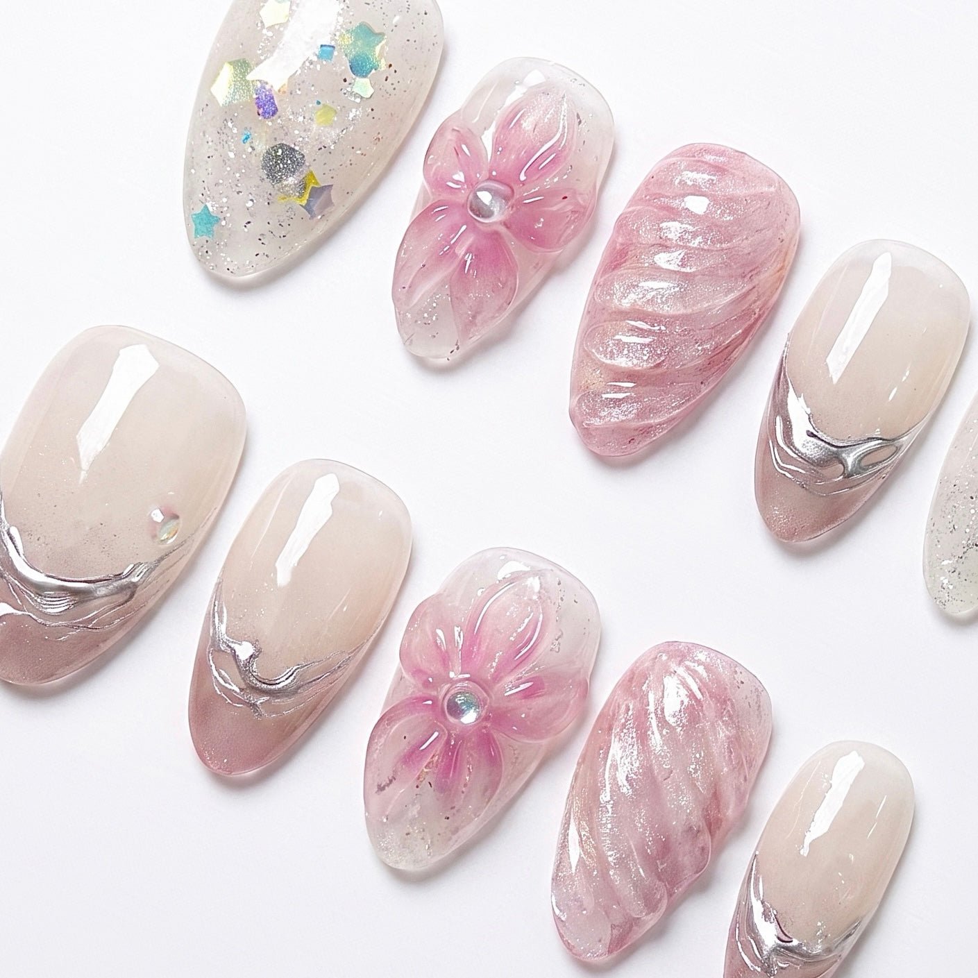 Close-up of Dewdrop Serenade press-on nails featuring dimensional pink flowers, water-inspired silver lines, sheer nude tones, and iridescent shimmer
