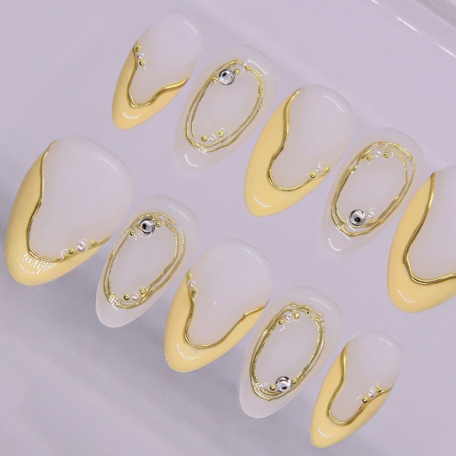 Minimalist nail design with warm yellow tones and fluid curves