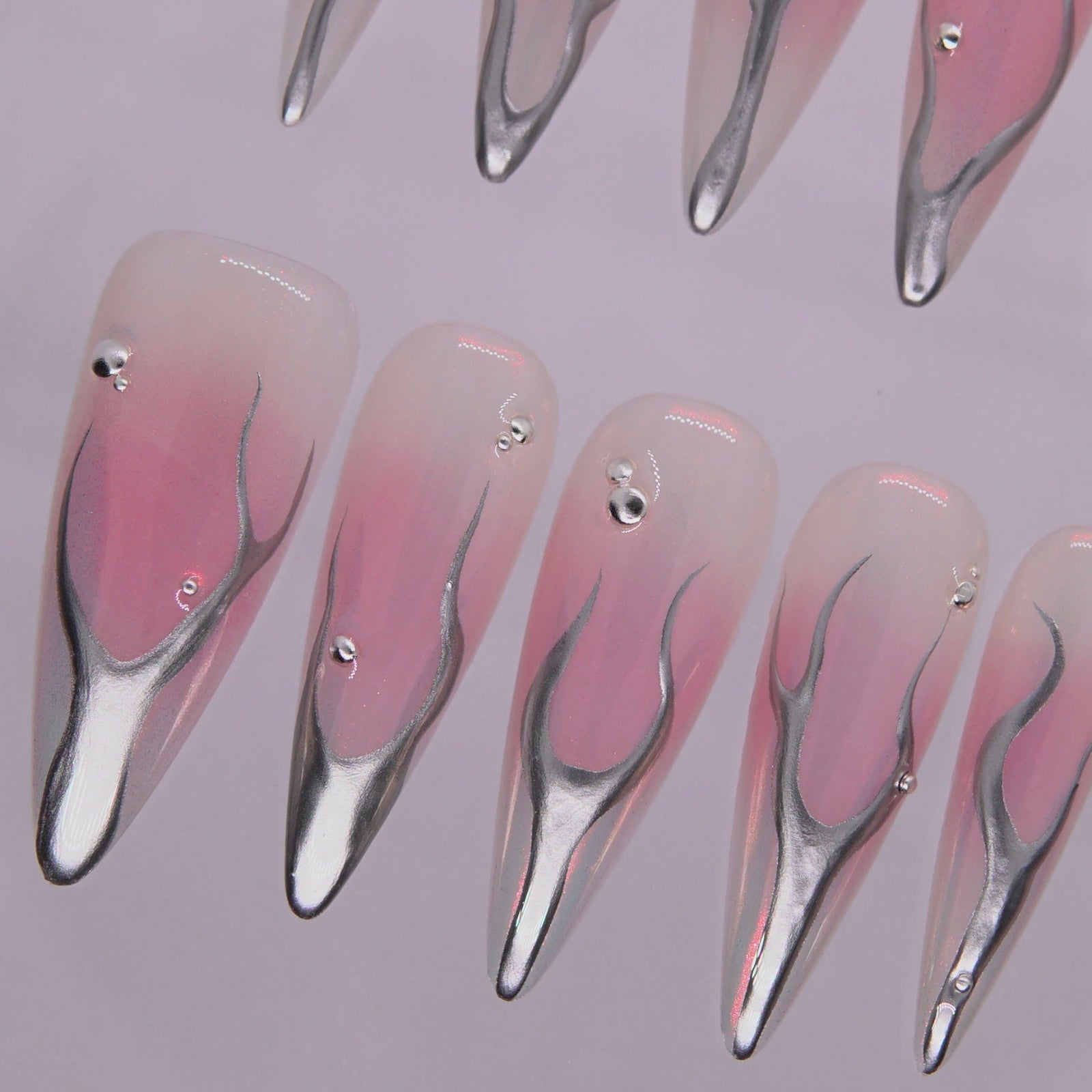 Macro view showing iridescent pink undertones and sculpted metallic lines.