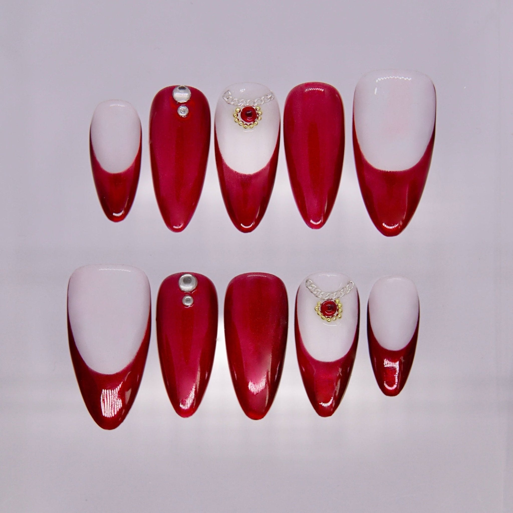 Snake zodiac press-on nails in deep wine red and ivory gradient with subtle gemstone accents representing Allure self love energy.
