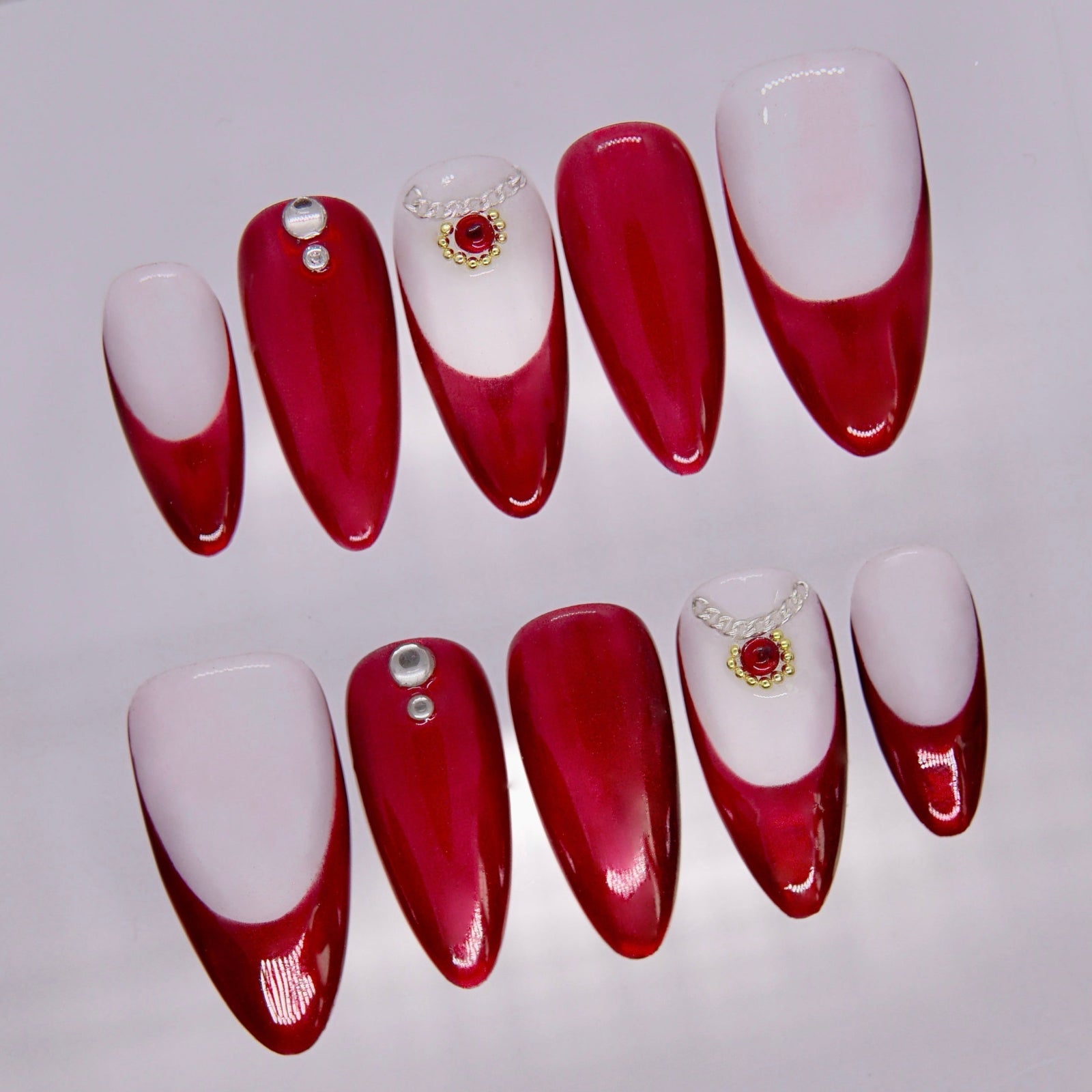 Close-up of Allure Snake press-on nails showing smooth red to ivory gradient and glossy finish.
