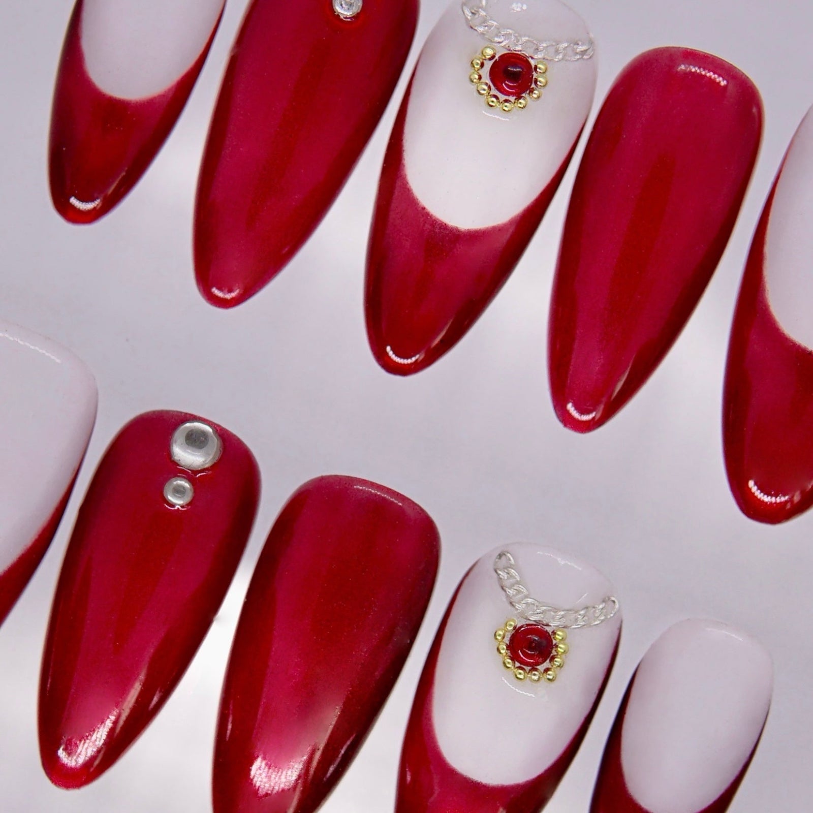Detail view of Snake zodiac Valentine nails with minimal gem accents and refined red tones.