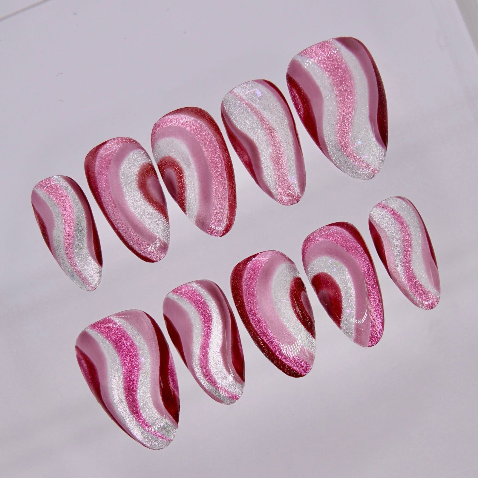 Close up of Dog Endear press on nails showing layered shimmer waves and soft heart design details