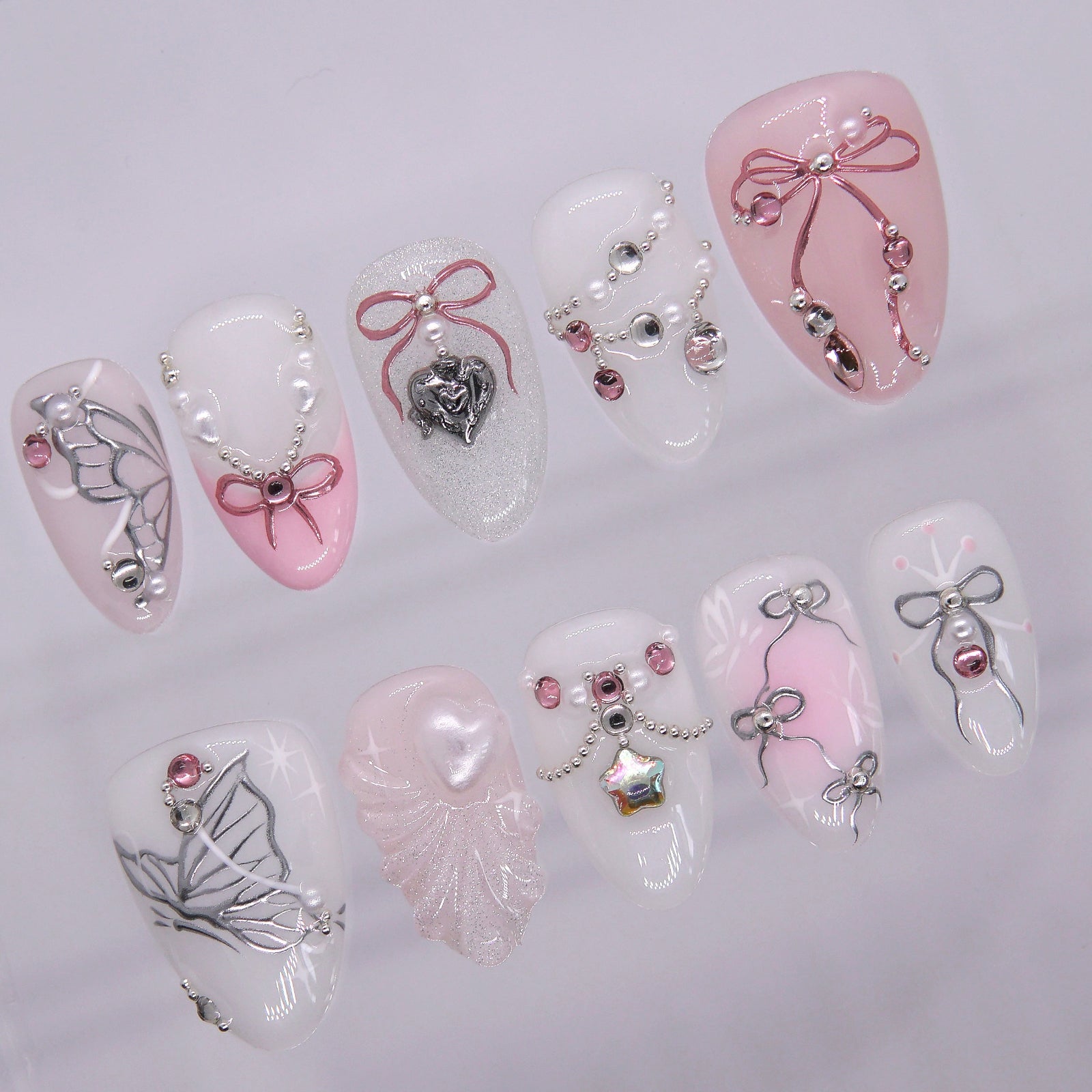 Close-up of ribbon nail design with pearl accents and soft blush tones.
