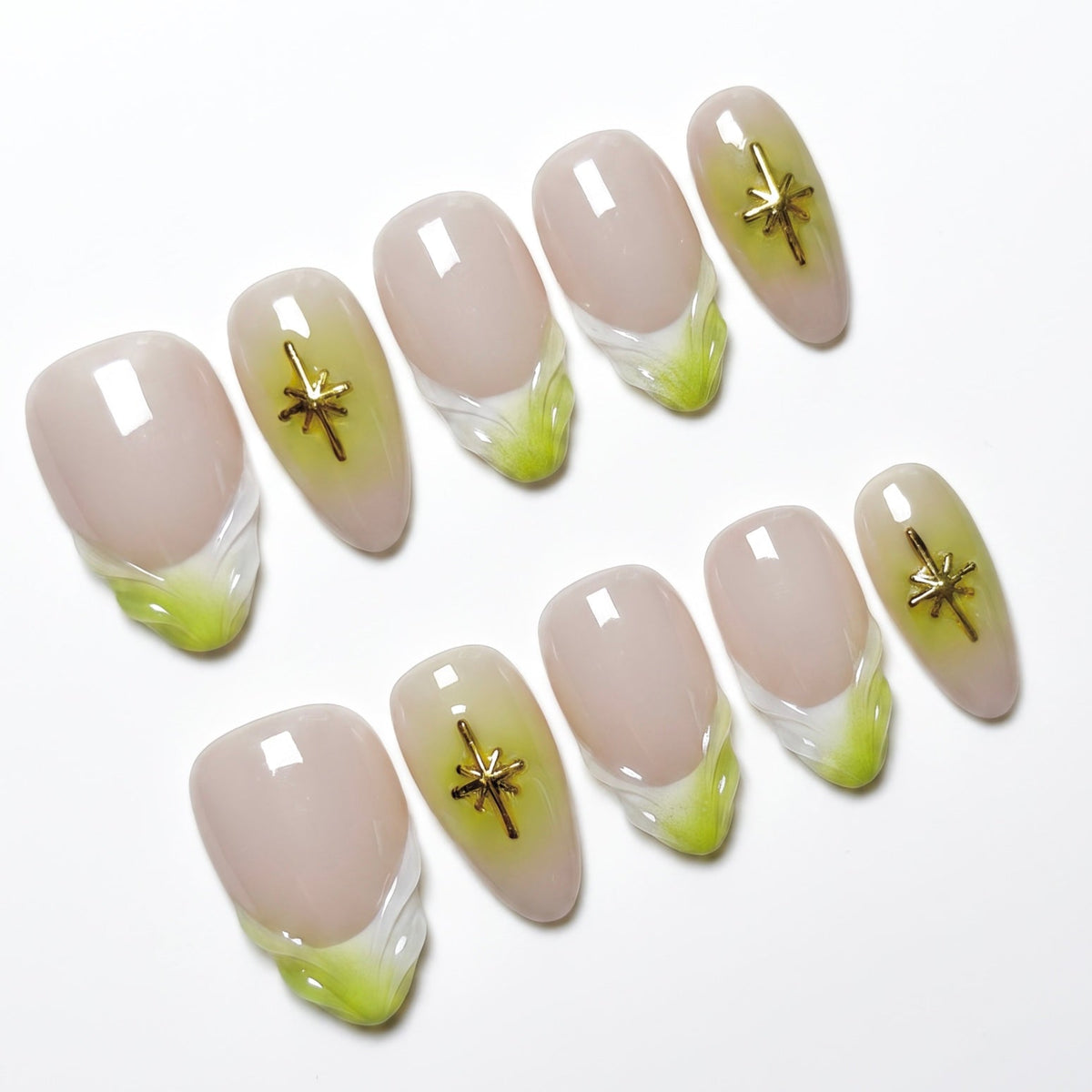 Close-up of handmade nude and lime French tip nails with gold star embellishments and glossy finish.