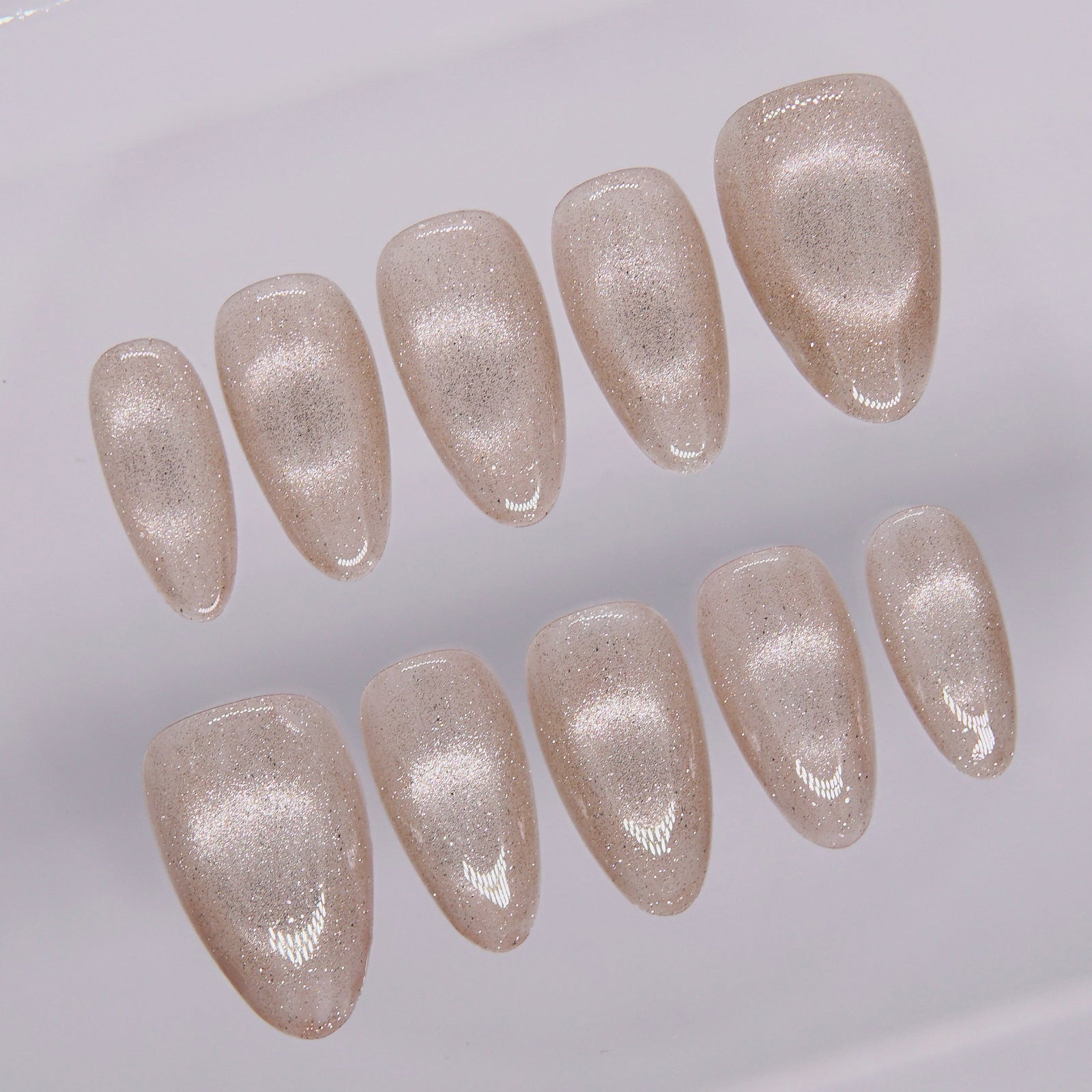 Close-up of shimmer texture on First Light champagne cat eye nails – subtle gold glow