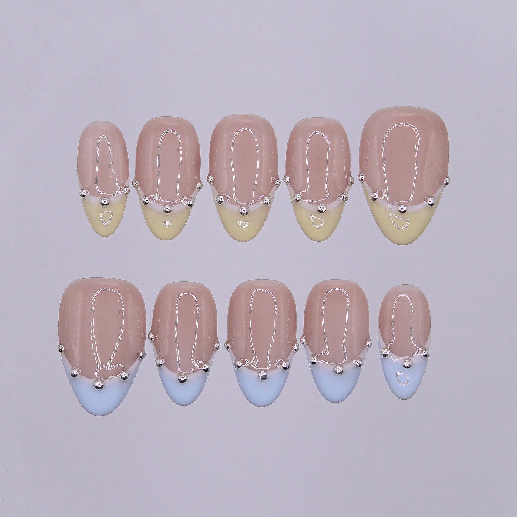 Handmade pastel French tip press-on nails with butter yellow and baby blue tips finished with delicate silver bead accents.