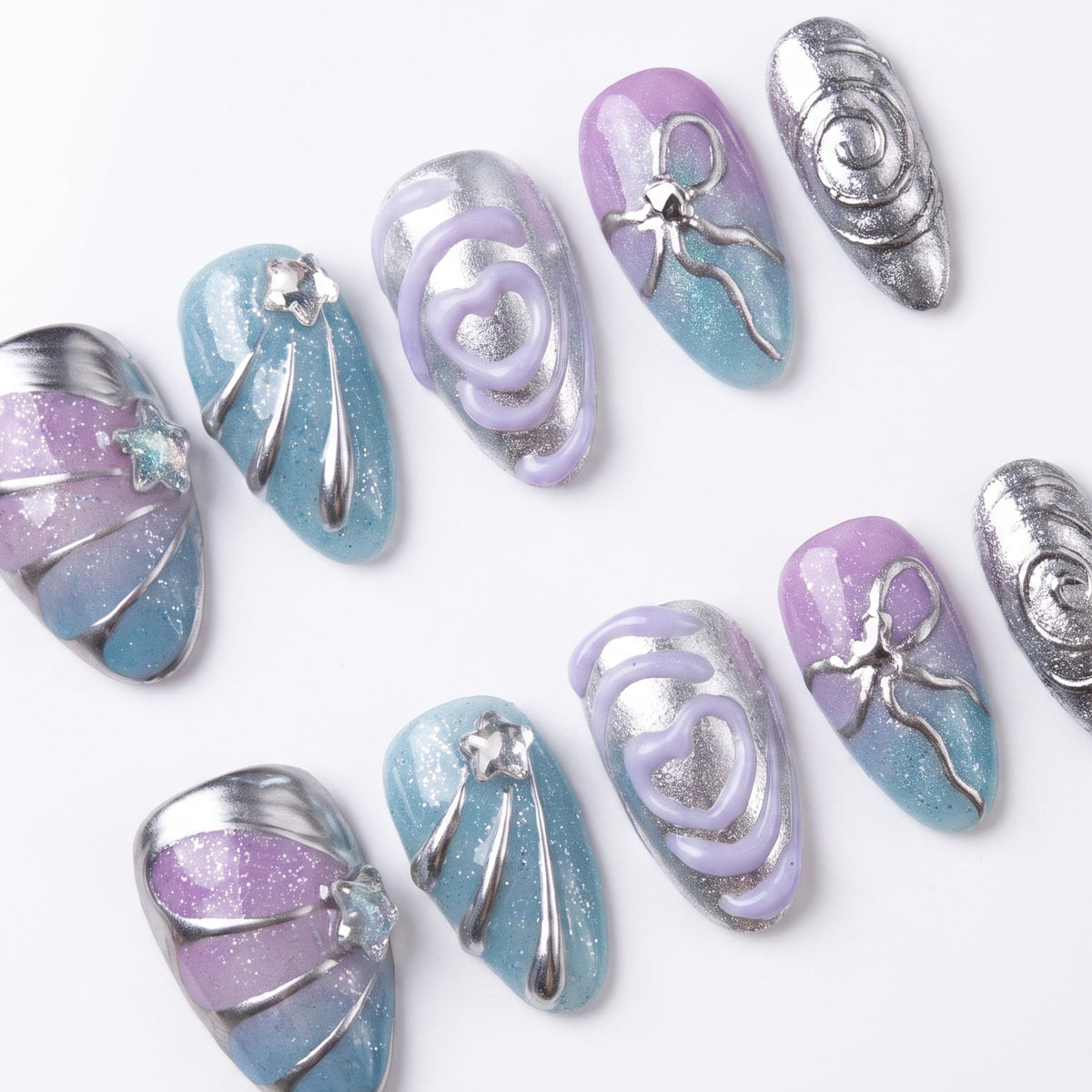 Flat lay of a pastel chrome nail set featuring sculptural silver lines and gradient tones.