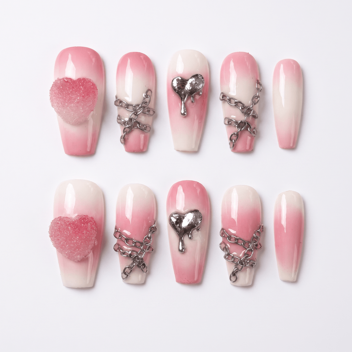 Pink-to-cream gradient press-on nails with silver chains and dripping heart charm – sweet yet edgy Fire Series design by Nailsium.