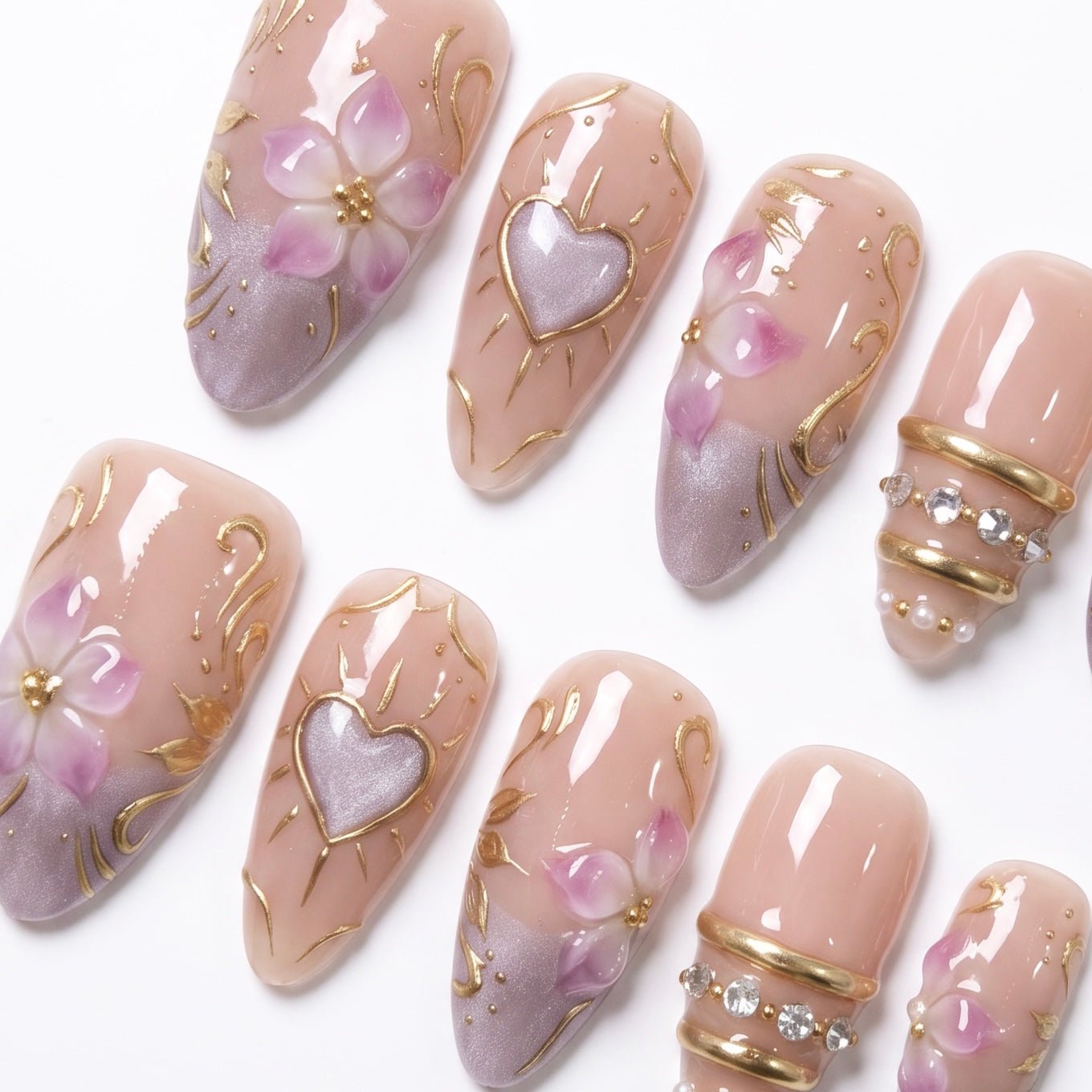 Detailed view of Heartspell Garden nail art with sculpted lilac petals, glowing heart-inspired accents, gold scrollwork, and crystal embellishments
