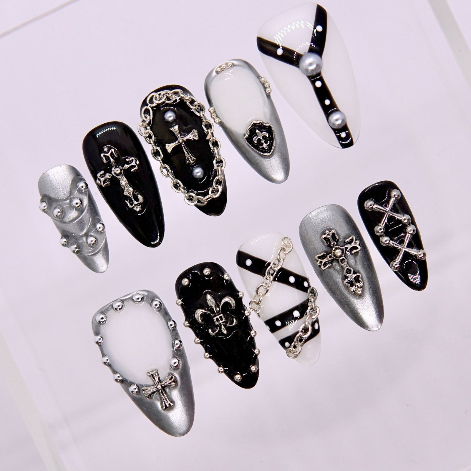 Close-up showing chrome frames and silver cross emblem on glossy black base.