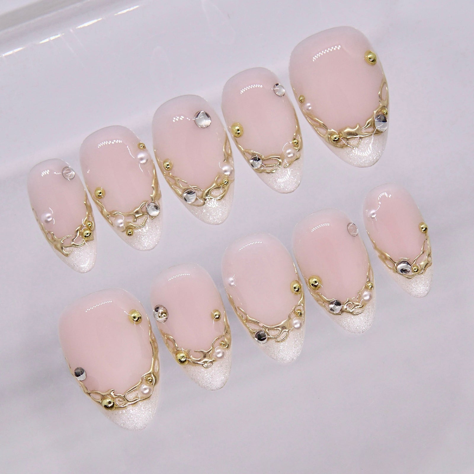 Close-up of neutral nails with fine gold detailing and glossy finish