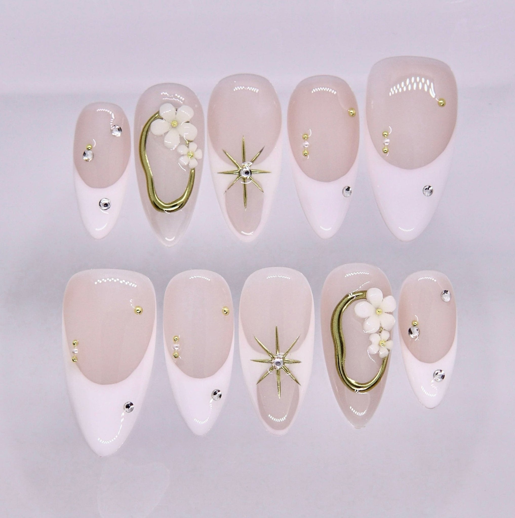 Nude and white press on nails with minimalist gold accents and clean design