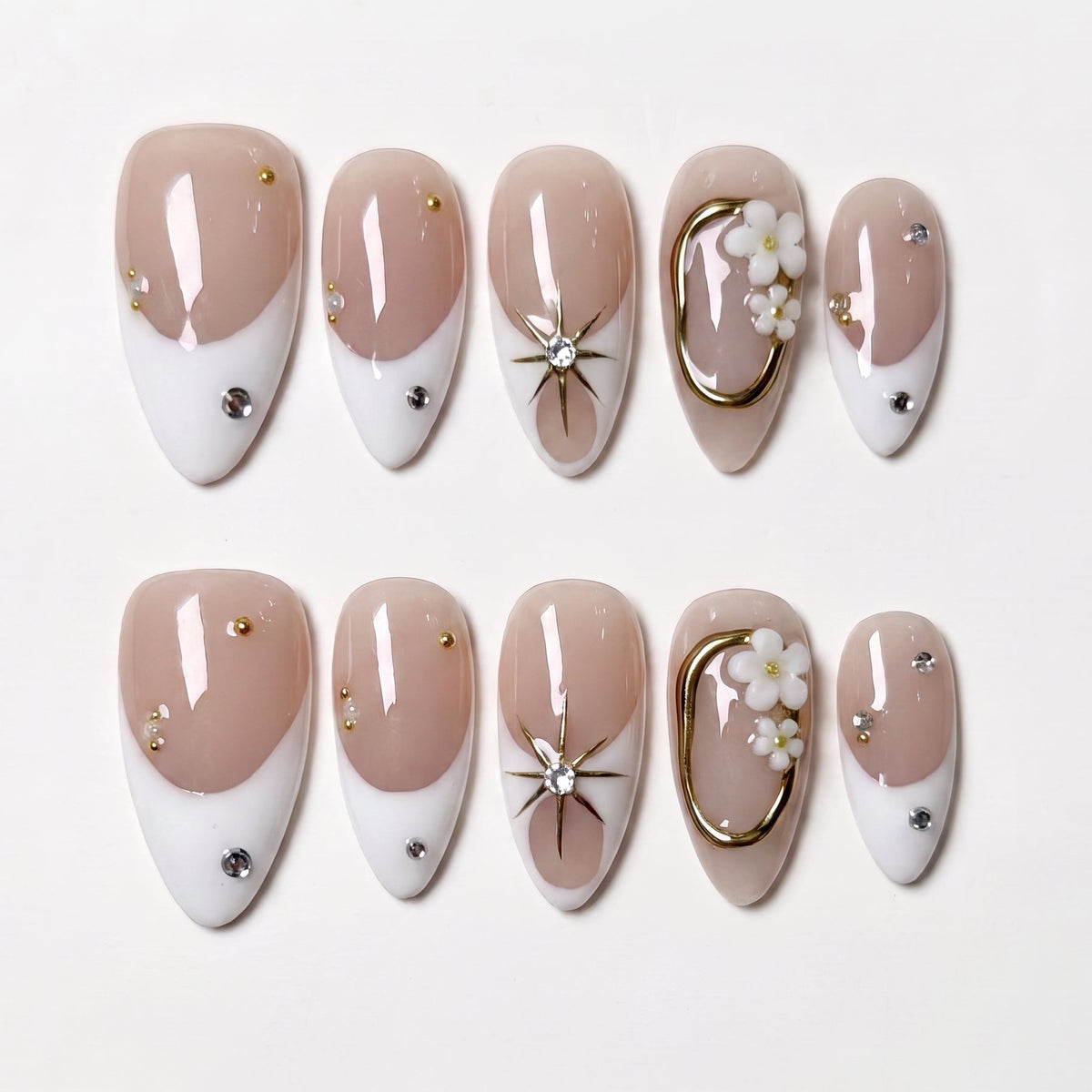 Nude and white press on nails with minimalist gold accents and clean design