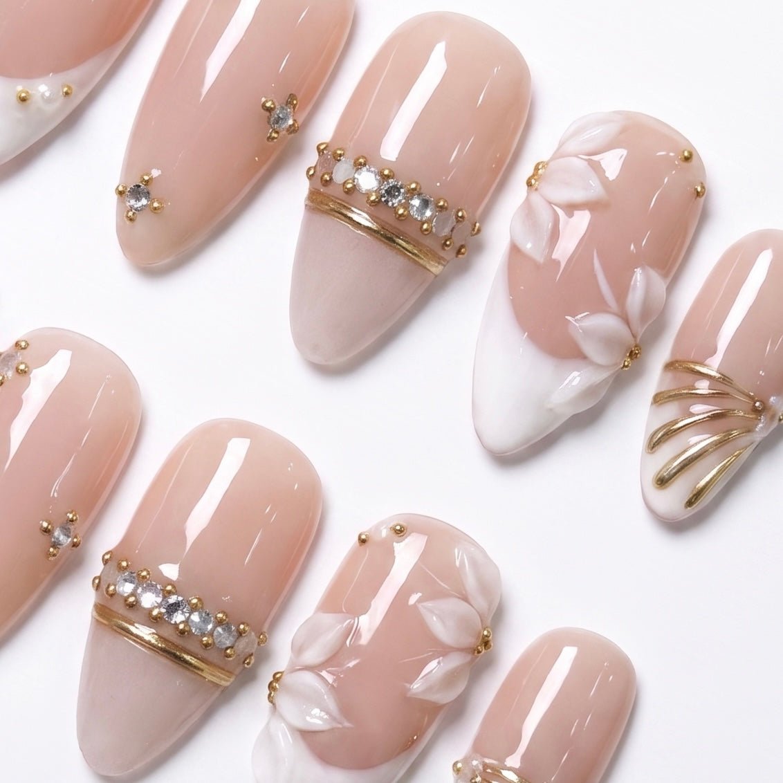 Detailed view of Ivory Petal Waltz nail art with sculpted white petals, ivory French tips, crystal bands, pearl accents, and gold petal details