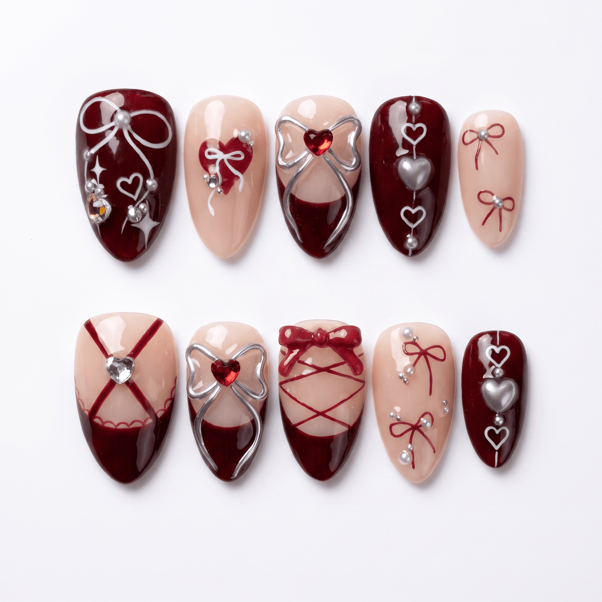 Crimson red press on nails with lace-up corset ribbon design and metallic heart accents.