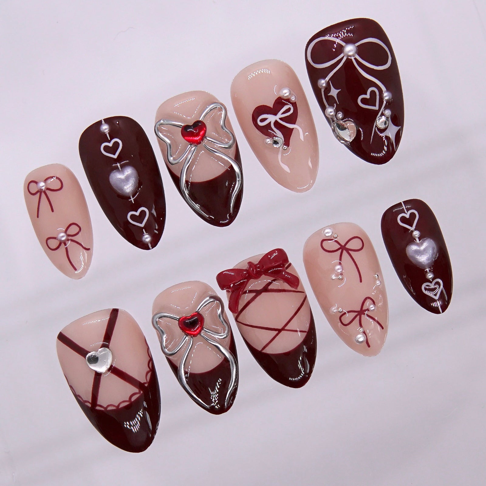 Wine red press on nails featuring corset details and glossy finish.