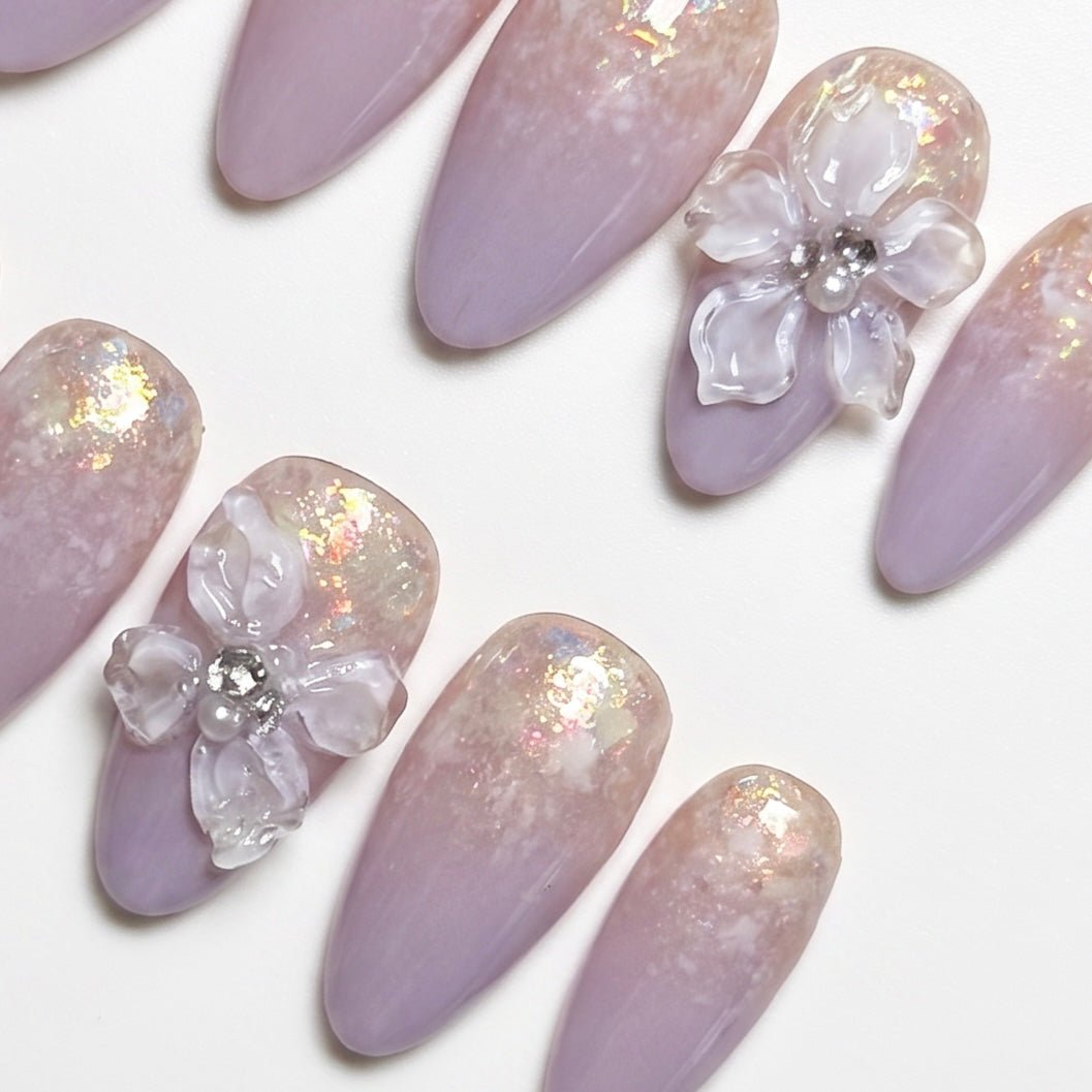 Close-up of 3D floral accent with subtle shimmer on lavender ombré press-on nails.