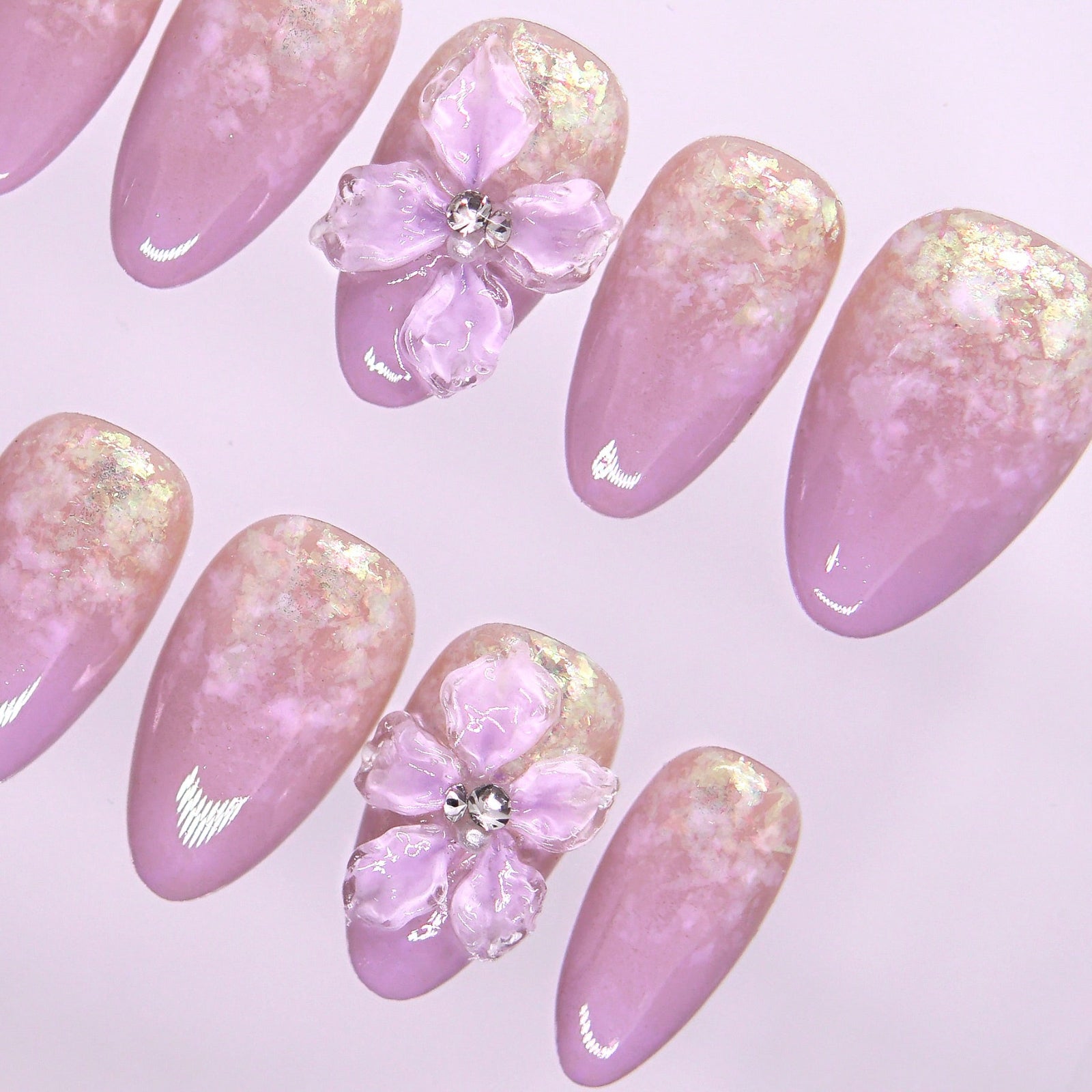 Close-up of 3D floral accent with subtle shimmer on lavender ombré press-on nails.