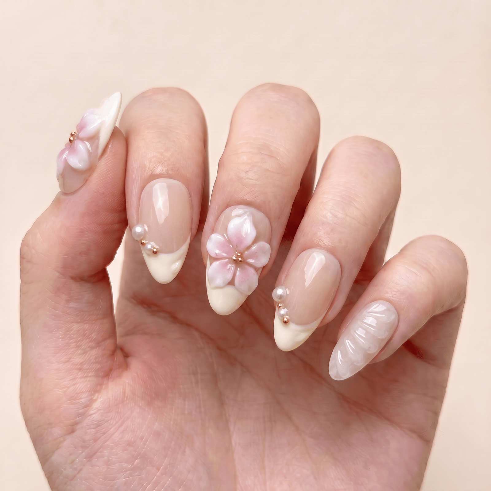 Floral French tip press-on nails worn on hands by Nailsium