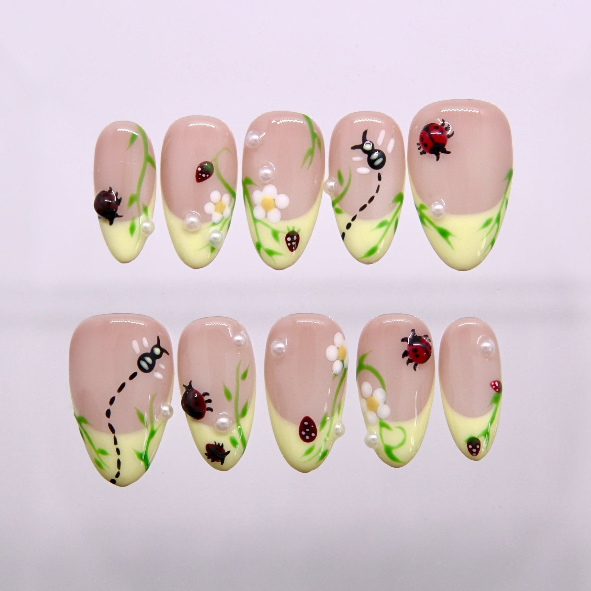 Little Things Bloom press-on nails with ladybugs, flowers, pearls, and pastel yellow tips