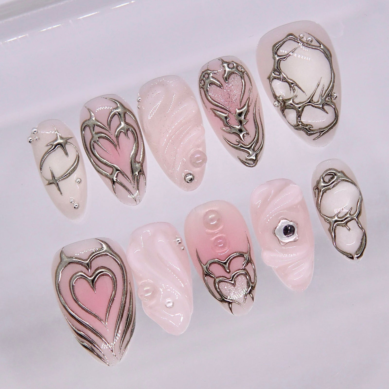 Chrome heart frame nail art with glossy pink base