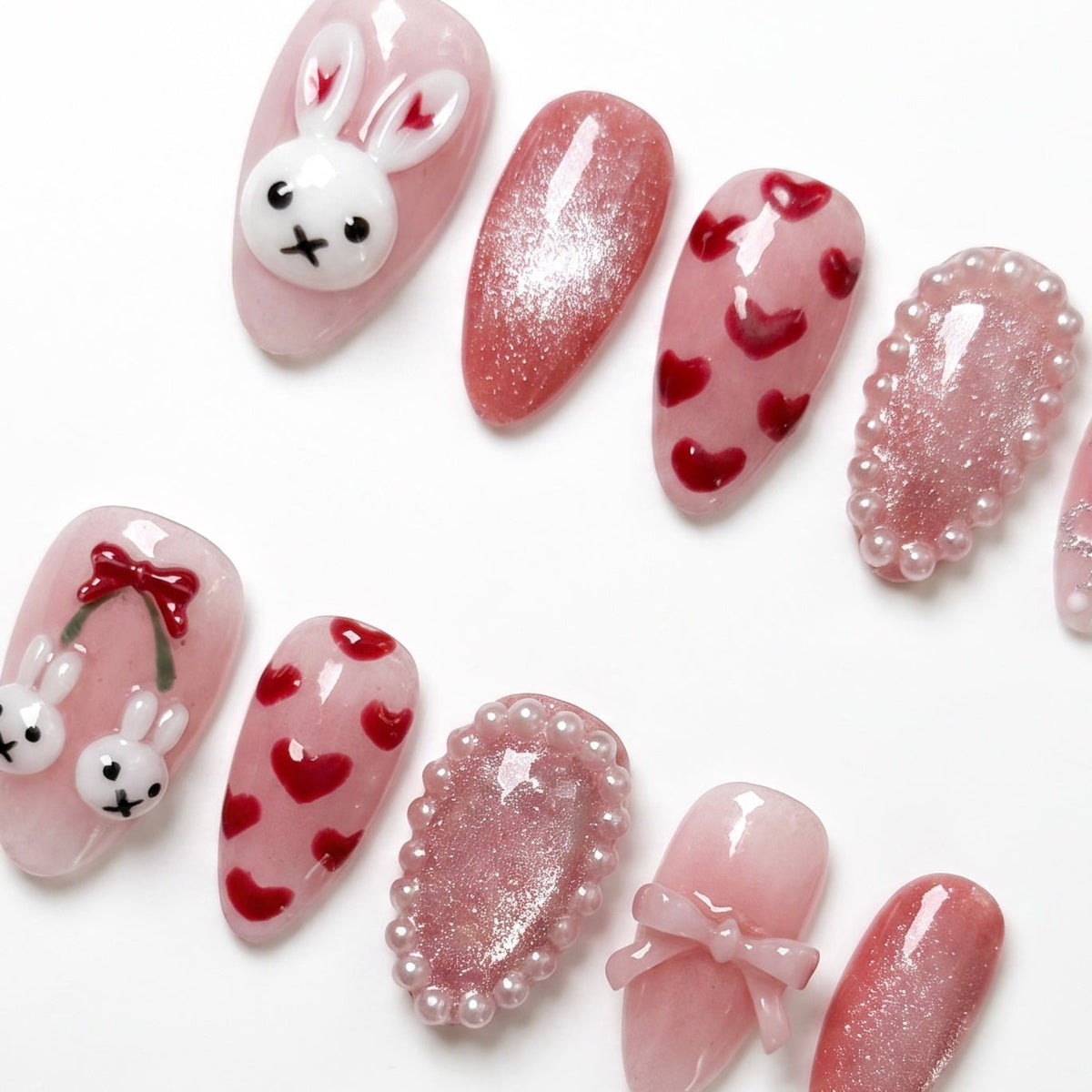 Detail view of Rabbit zodiac Valentine nails with soft pink tones, bow accents, and playful bunny charm details.