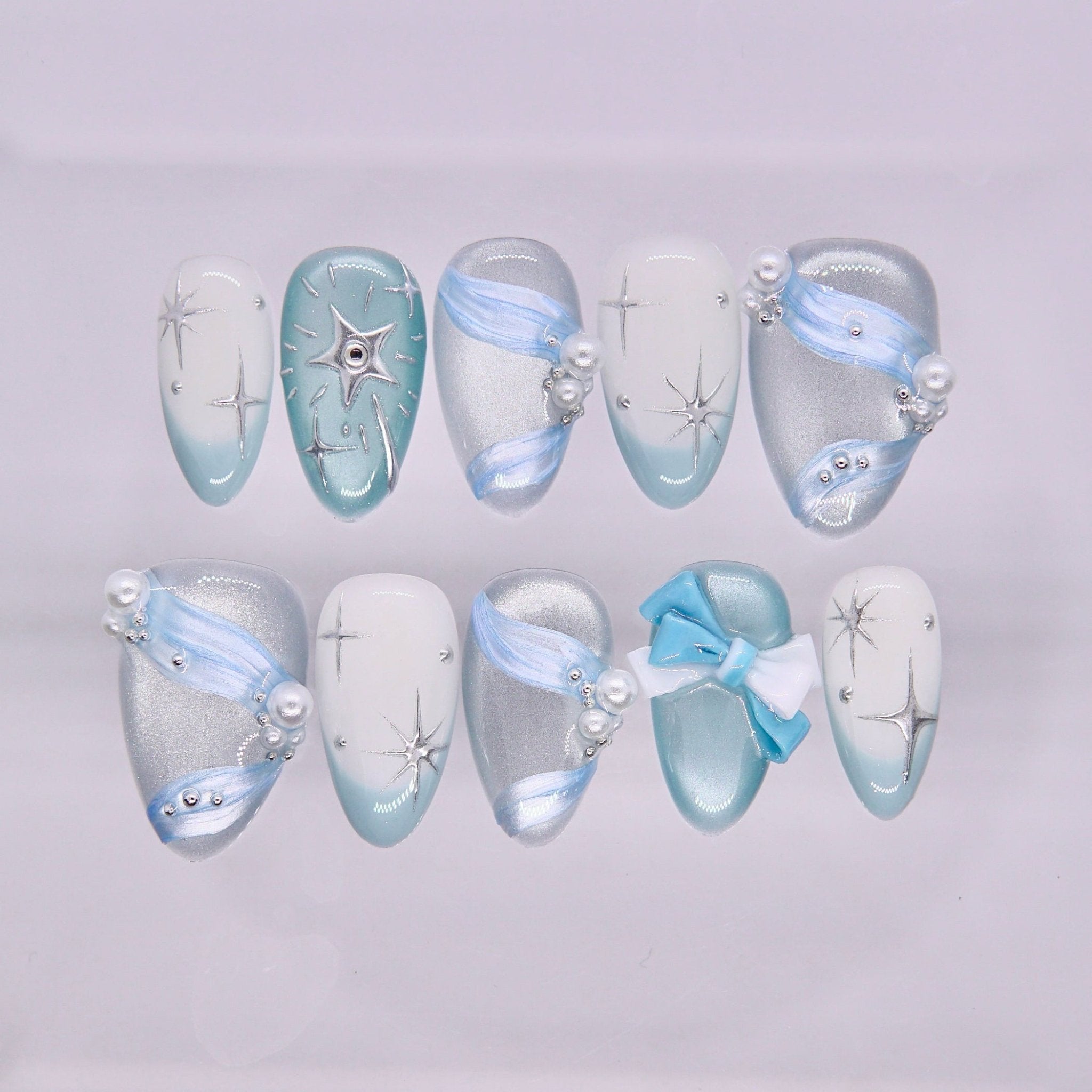 Blue press on nails with bow detail, shimmer finish, and dreamy fairy-inspired design