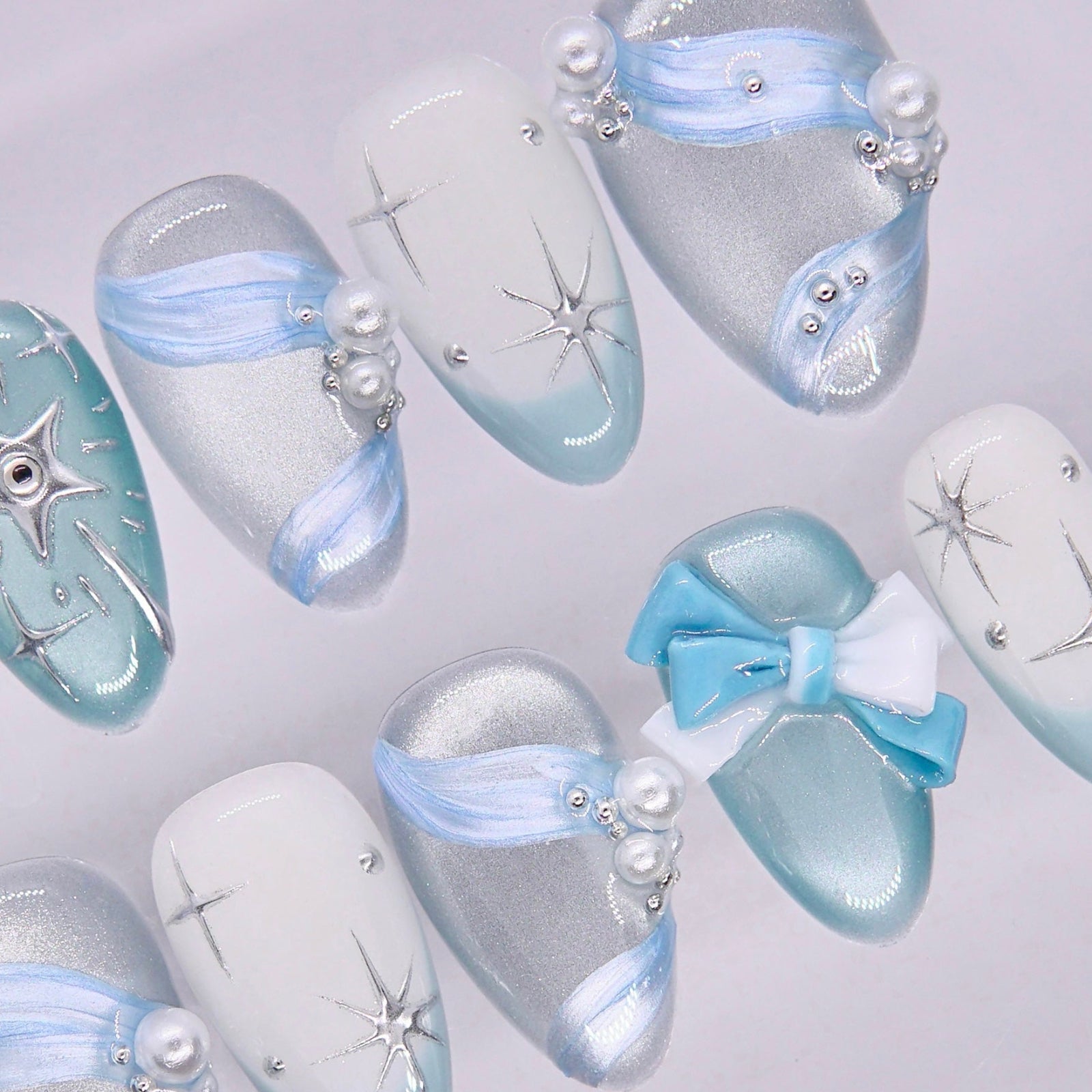 Dreamy nail art with light blue tones, glossy texture, and subtle sparkle