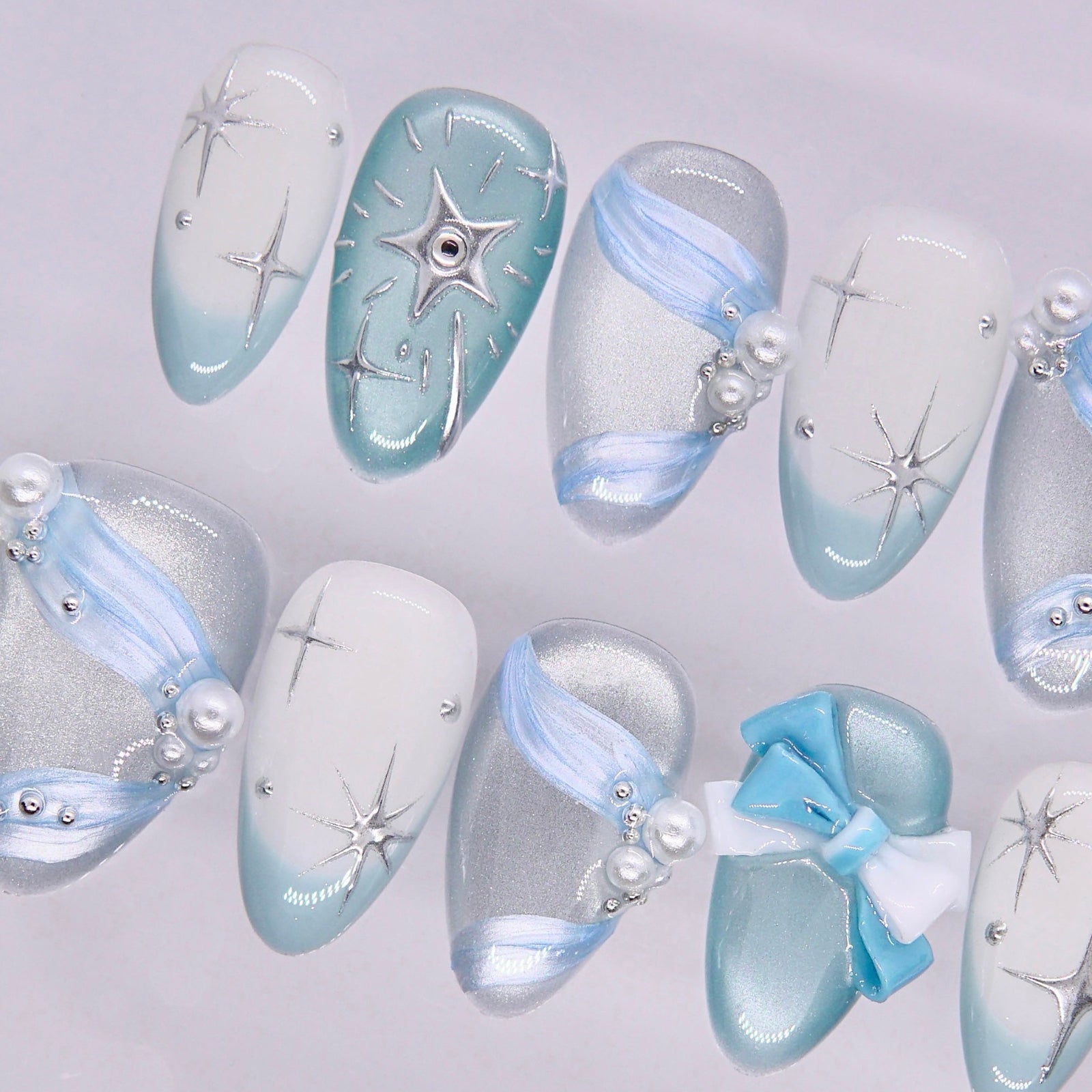 Dreamy nail art with light blue tones, glossy texture, and subtle sparkle