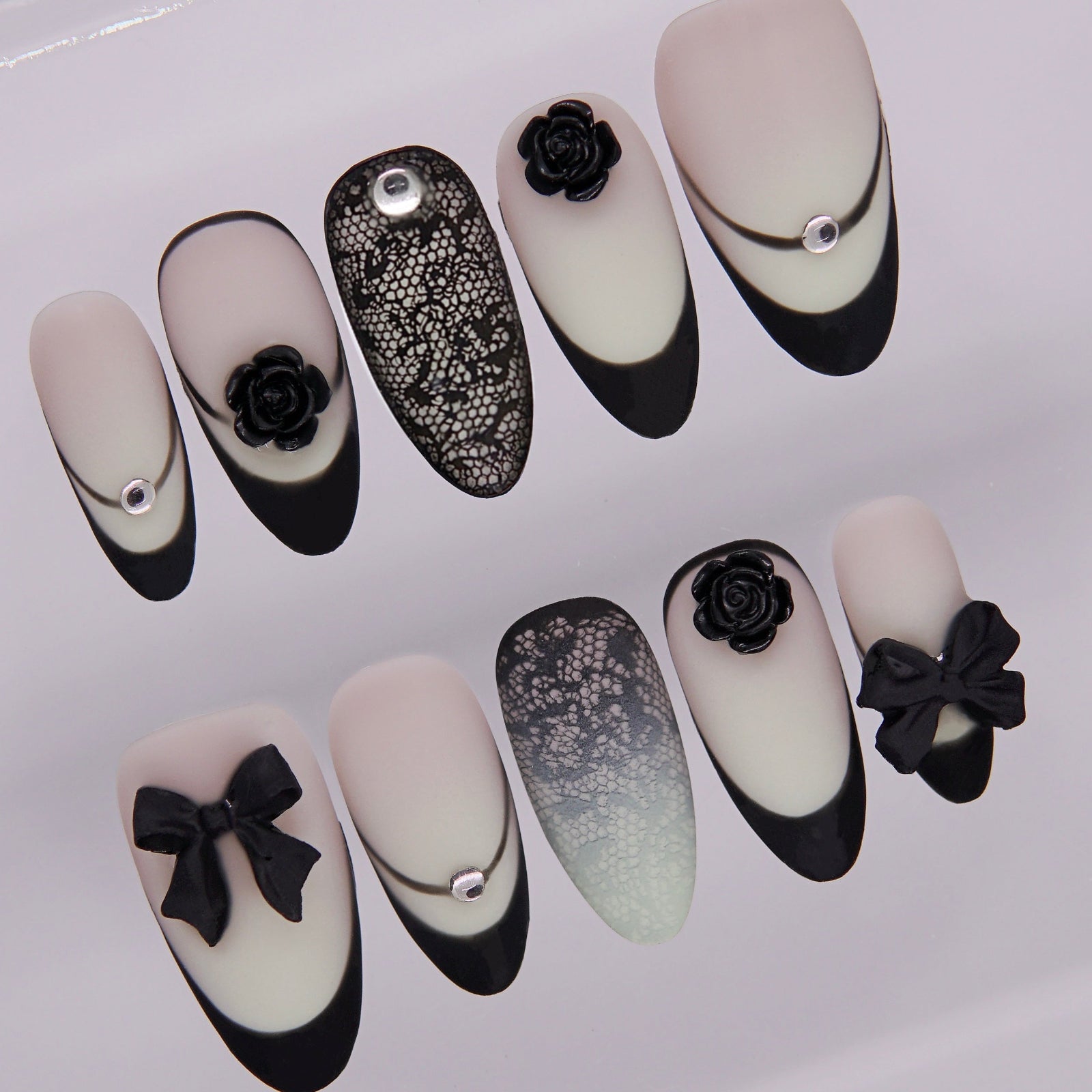 Close-up of lace overlay nail with rhinestone highlight.