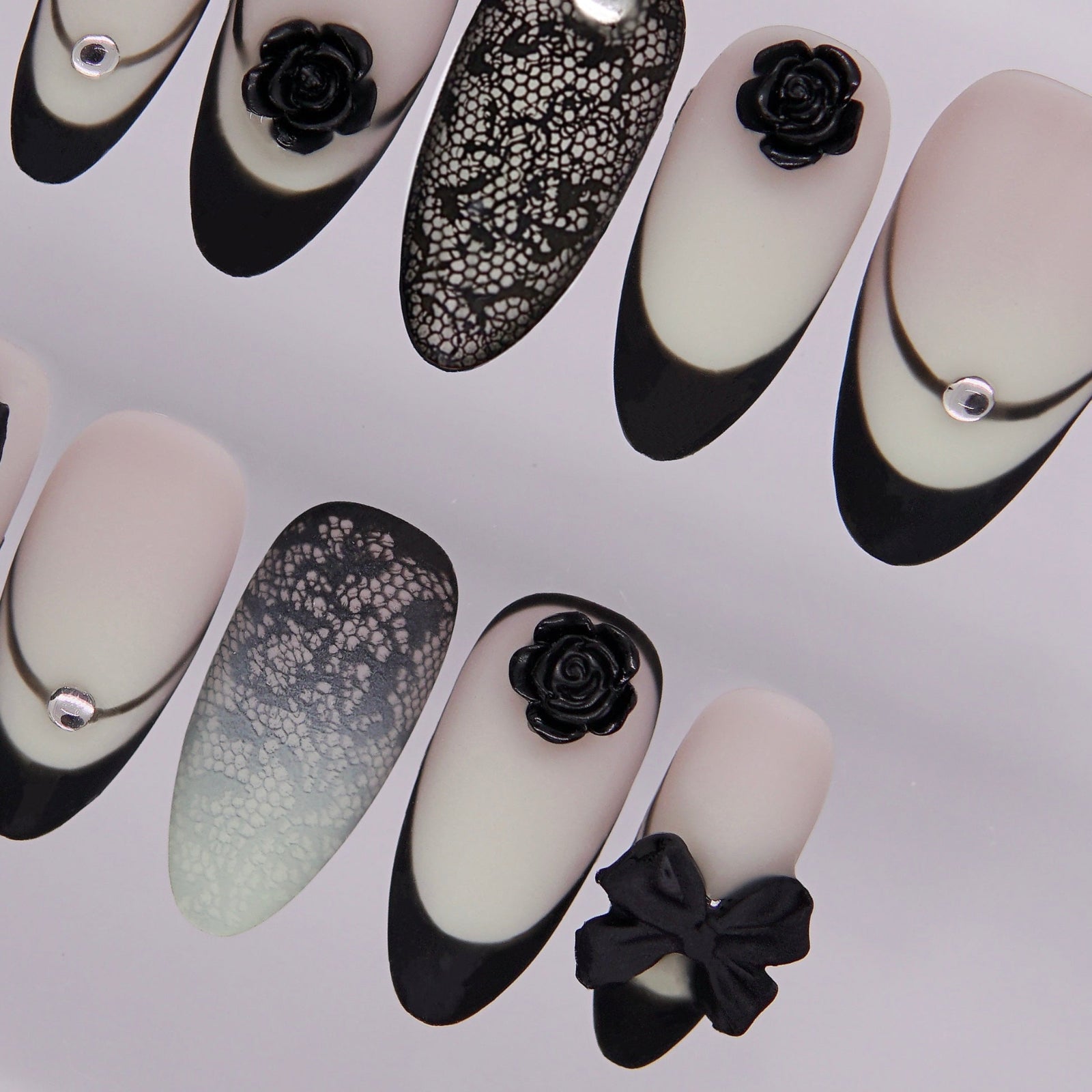 Close-up of lace overlay nail with rhinestone highlight.