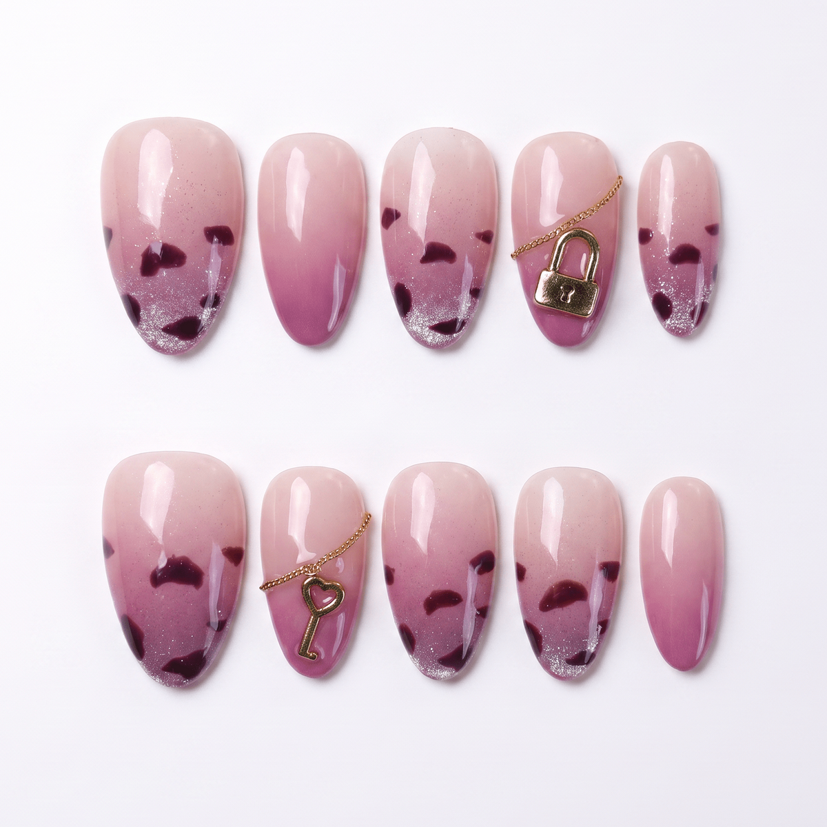 Glossy pink press-on nails with leopard tips, lock and key charms – full layout