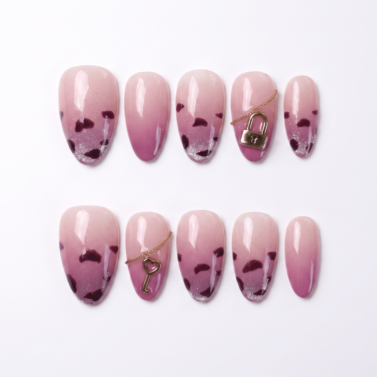 Glossy pink press-on nails with leopard tips, lock and key charms – full layout