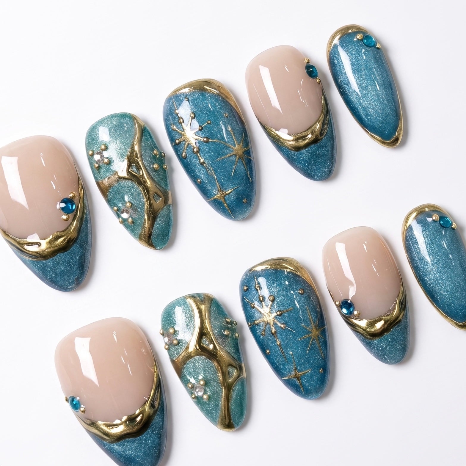 Close-up of Moonlit Lagoon press-on nails featuring blue shimmer, gold ripple details, constellation nail art, pearl accents, and tiny gold beads