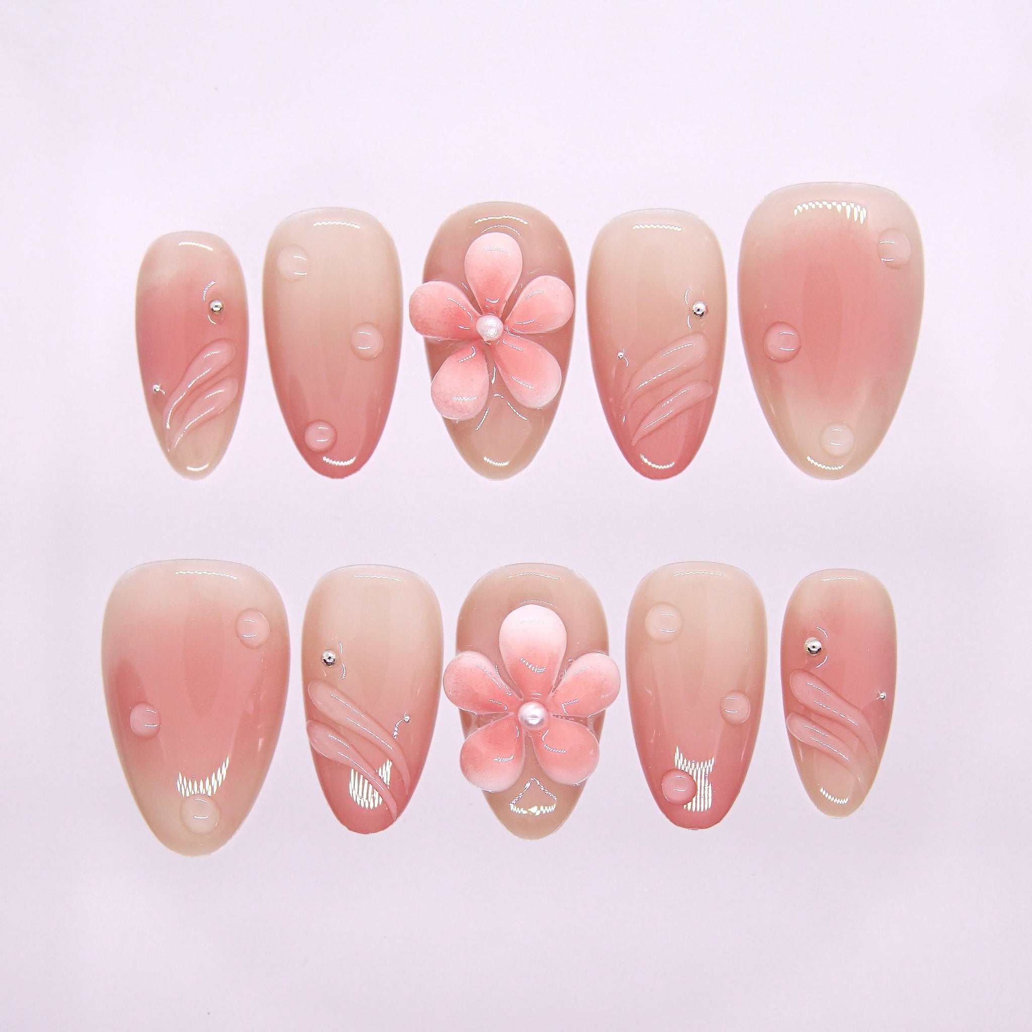 Morning Dew press-on nails with nude-pink gradient, pearl-centered flower, and dew-drop accents – soft Earth · Calm design by Nailsium.
