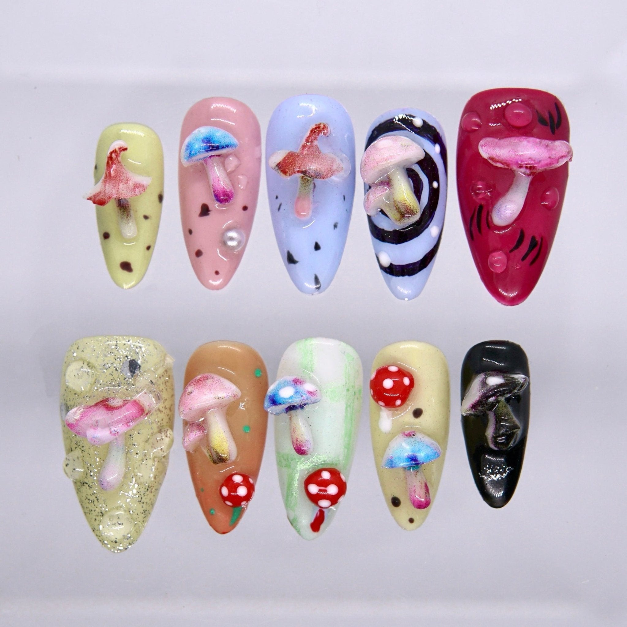 Long almond press on nails with colorful 3D mushroom designs, playful hand-painted details, and glossy whimsical finish
