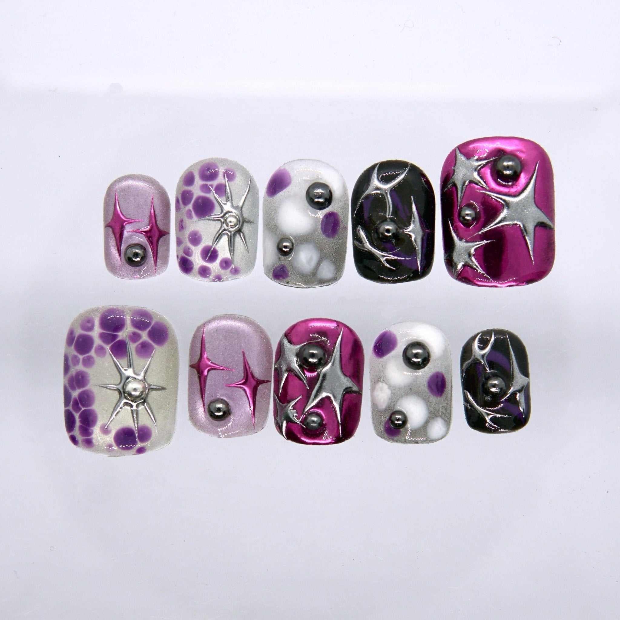Short square press on nails with pink chrome, black gloss, silver star details, and violet abstract bubble patterns
