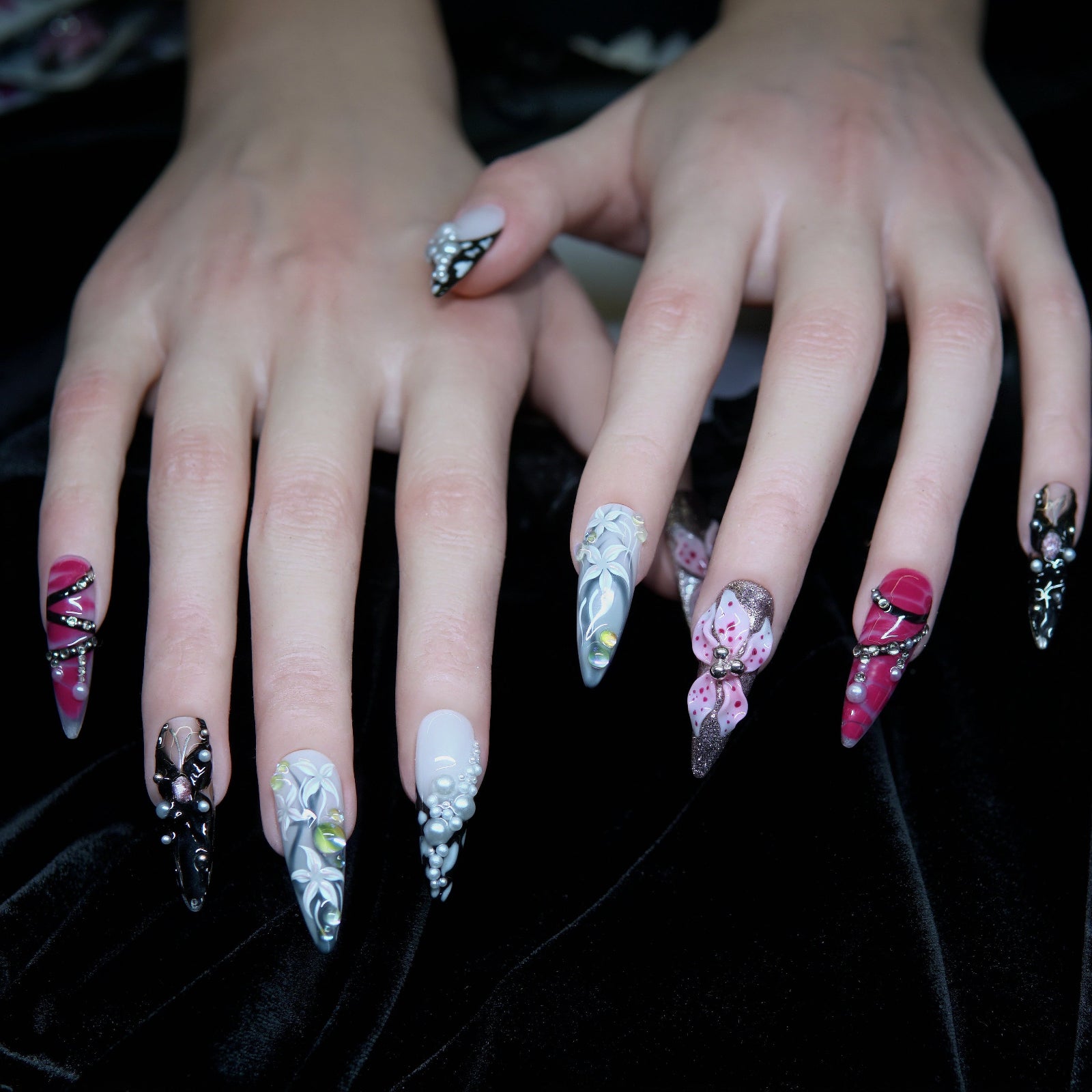 Obsidian Bloom nails worn on hand, reflecting soft light and dark elegance.