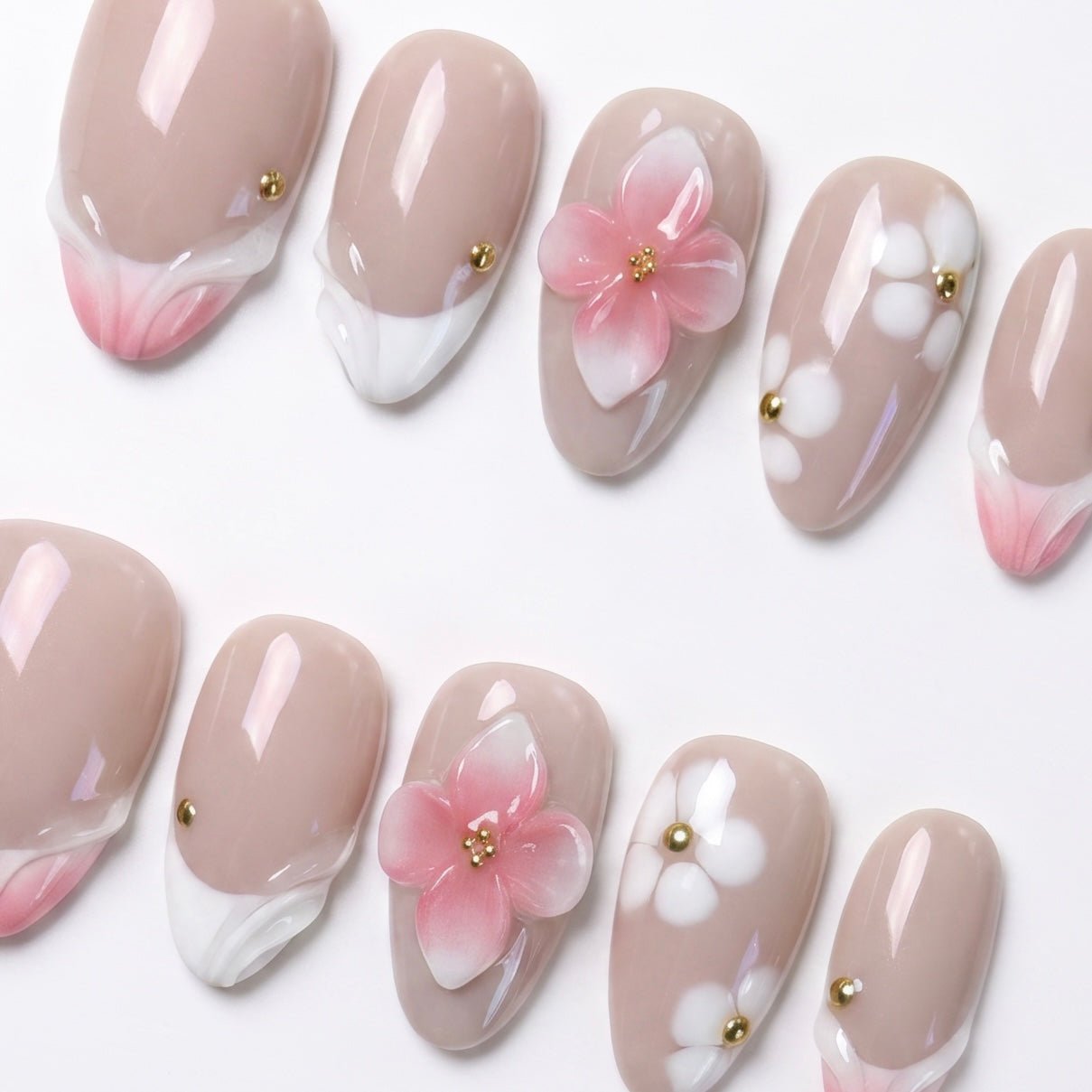 Close-up of handmade peach floral press-on nails with sculpted 3D flowers, soft nude base, and gold embellishments