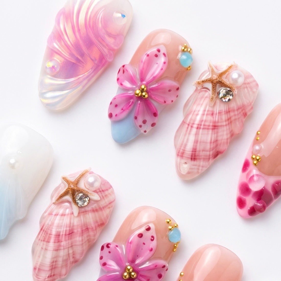 Seashell inspired pink press-on nails with hand painted flowers by Nailsium