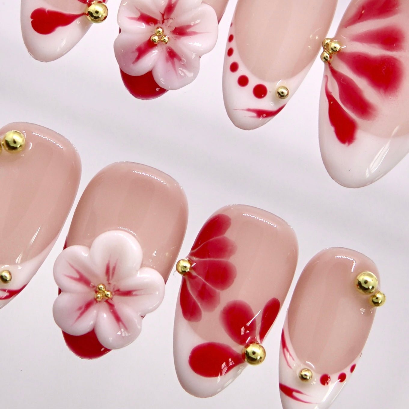 Sheer nude press-on nails featuring watercolor floral patterns and 3D flowers