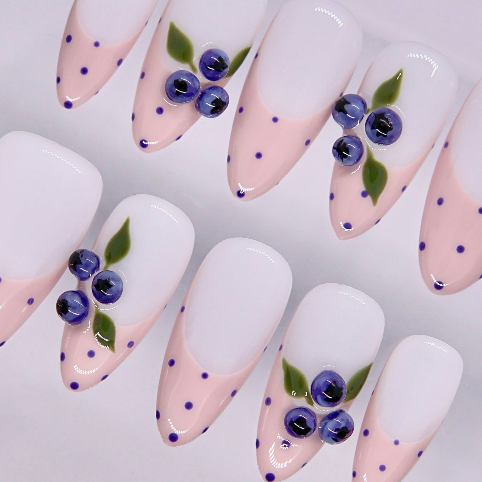 Minimal nail design with soft tones and playful blueberry elements