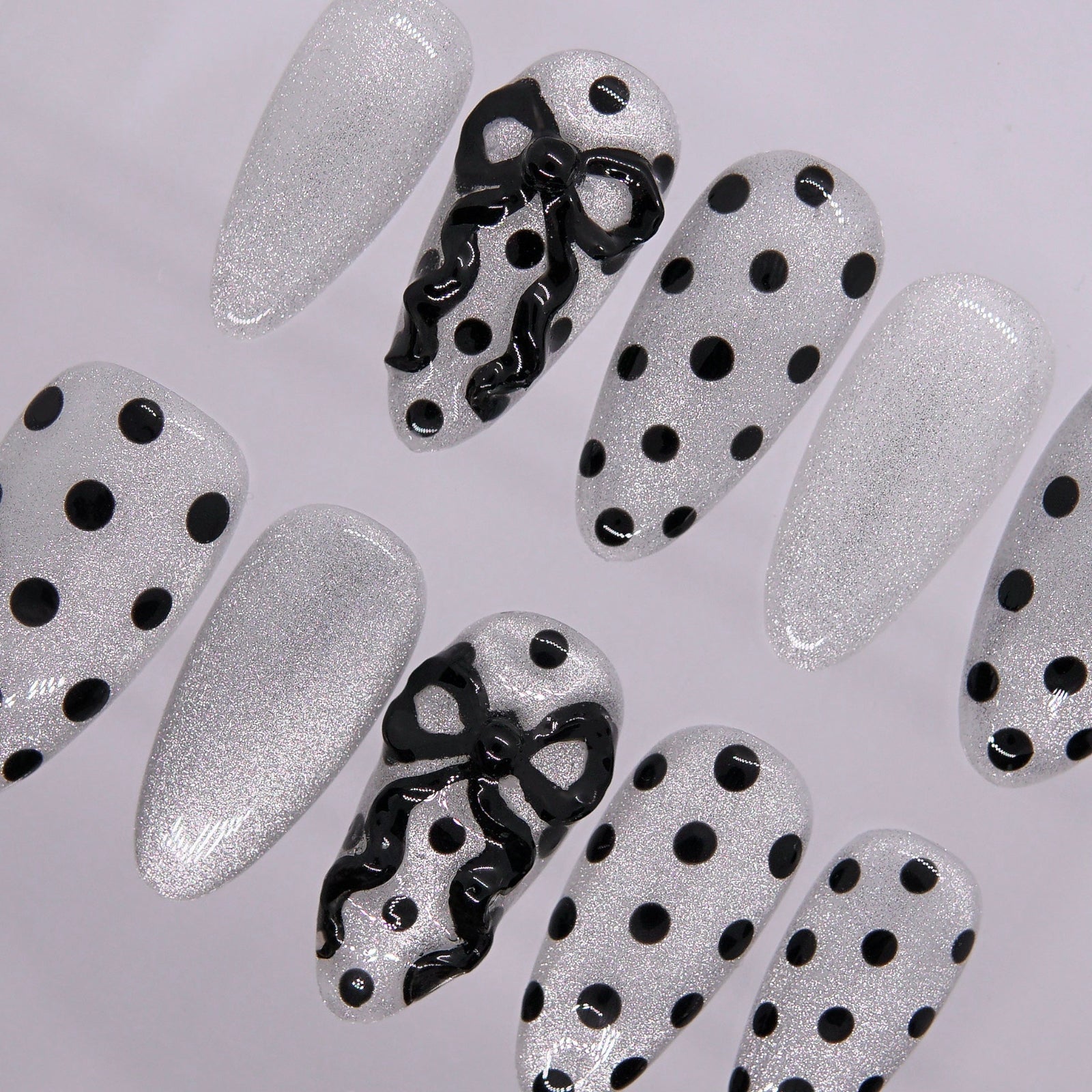 Sculpted black bow detail on Pretty Polka nail.