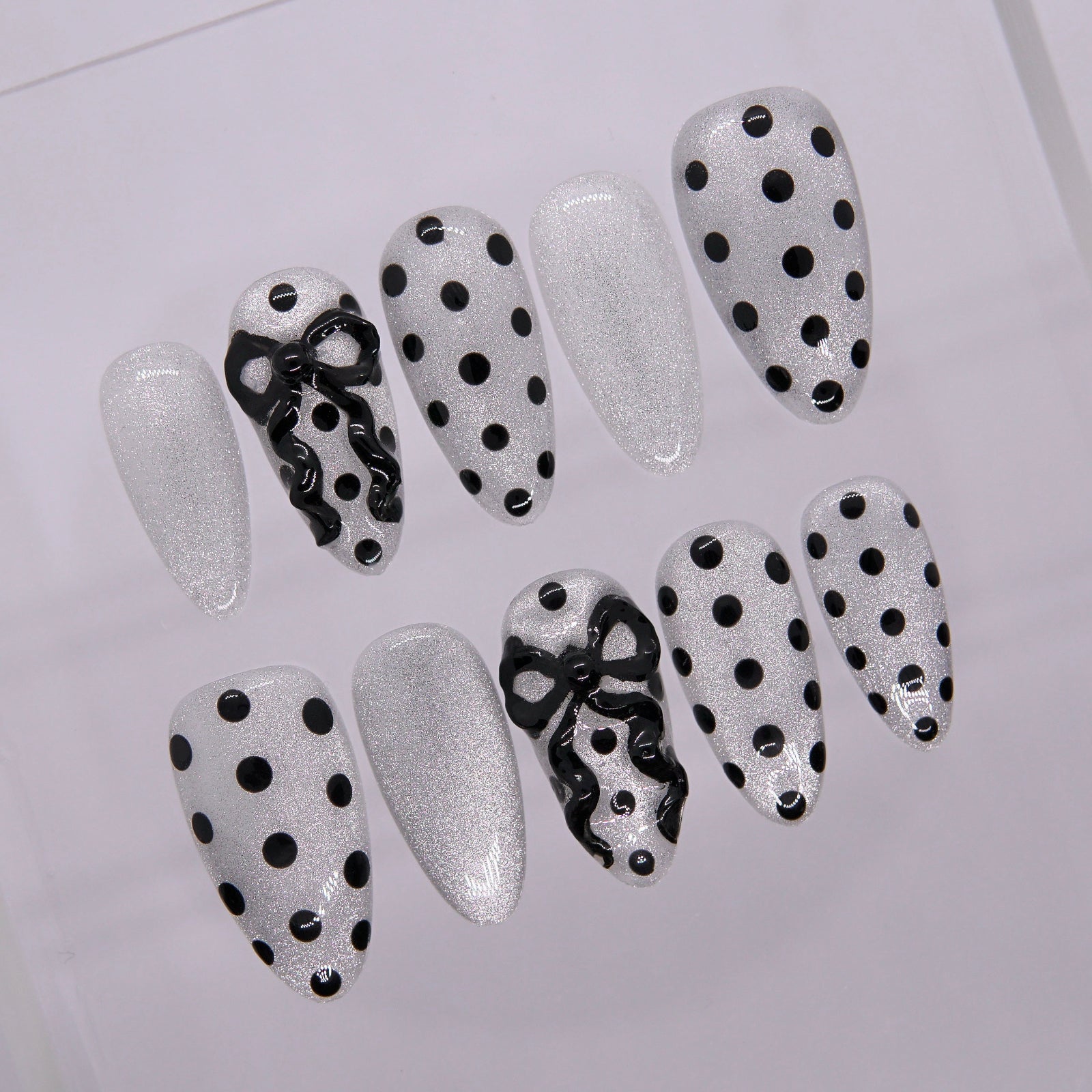 Close-up of glossy white base with black dots.
