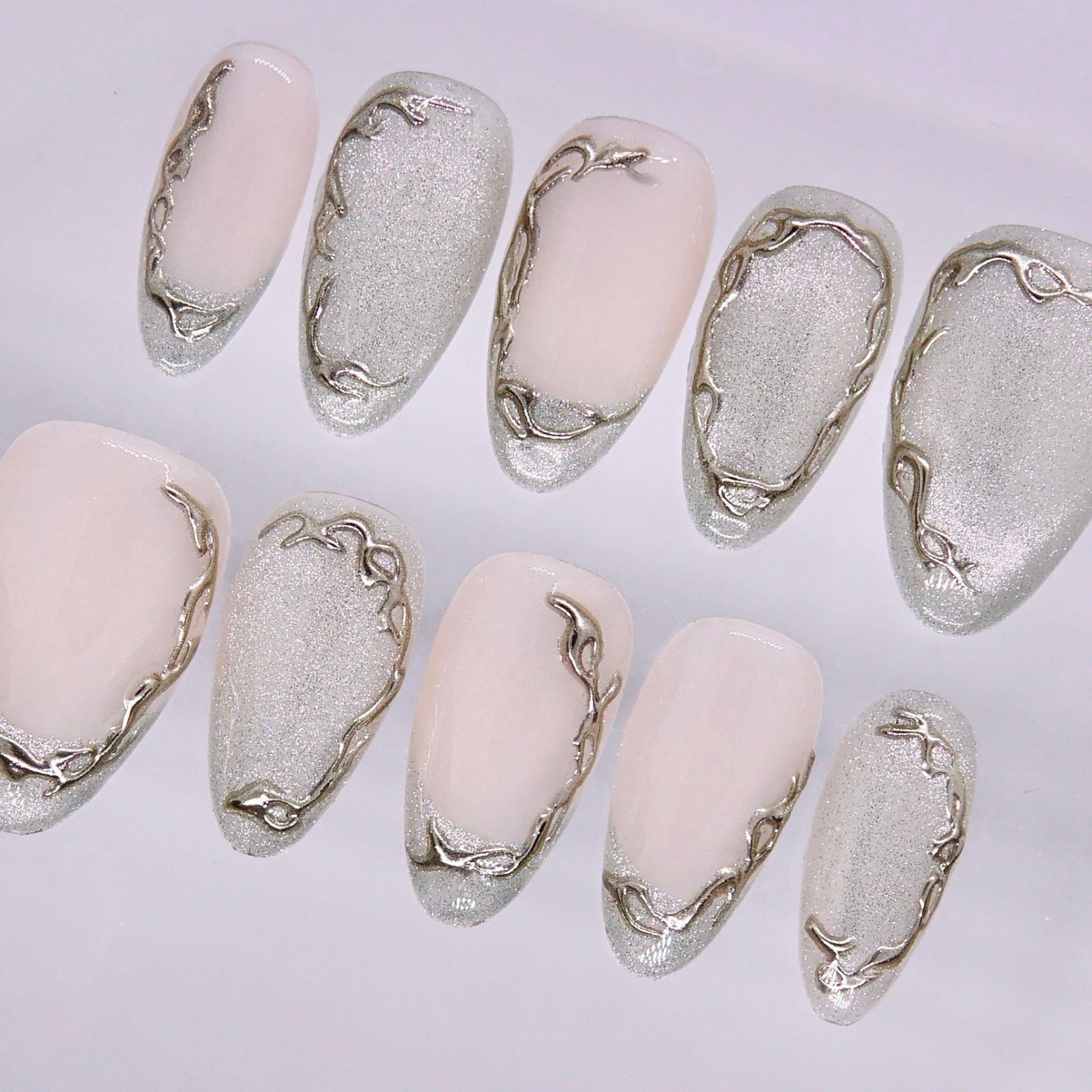Minimal nail design with soft nude tones and organic metallic lines