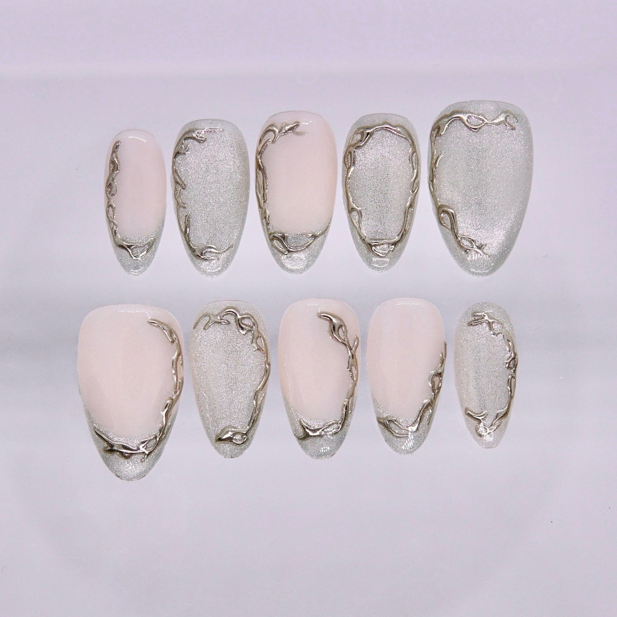 Nude press on nails with soft metallic accents and minimal design