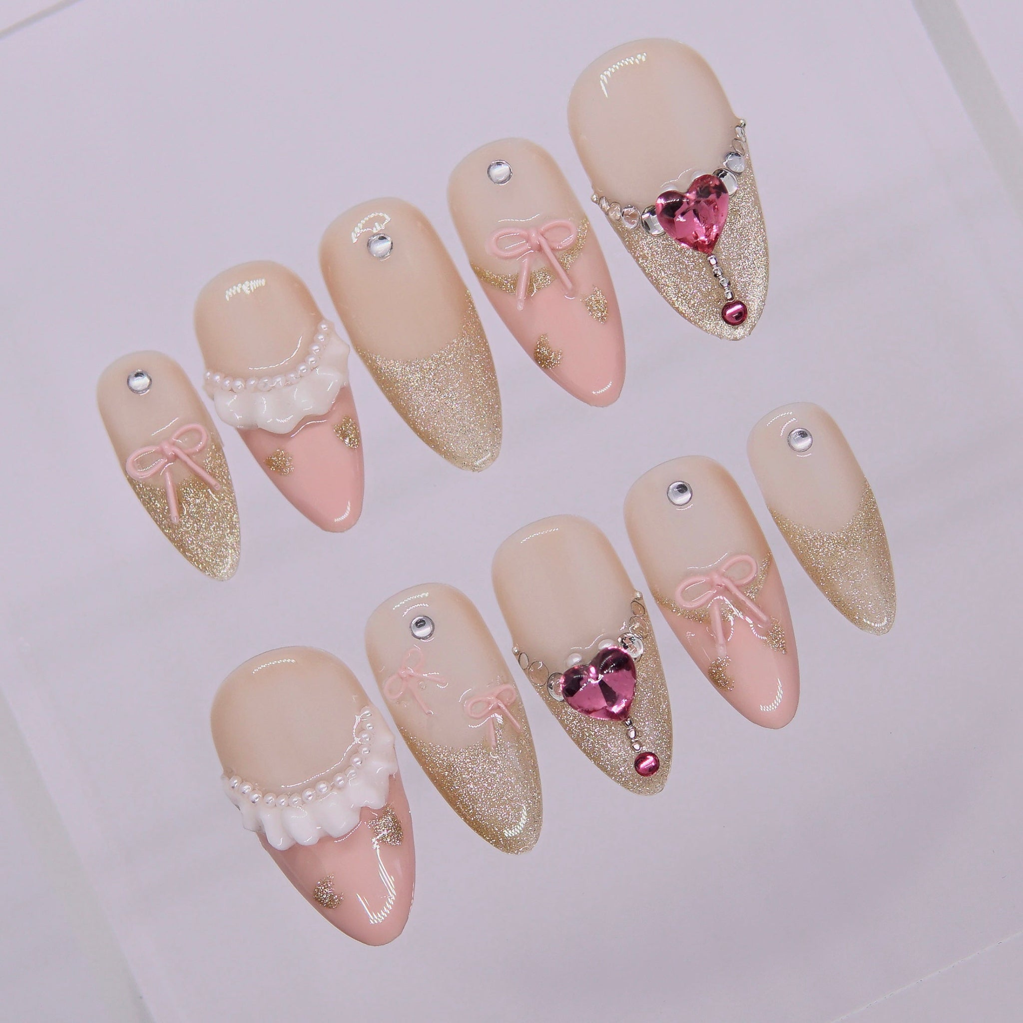Side angle showing blush gold gradient and pearl accents on Sugar Dream Ribbon Agenda nails
