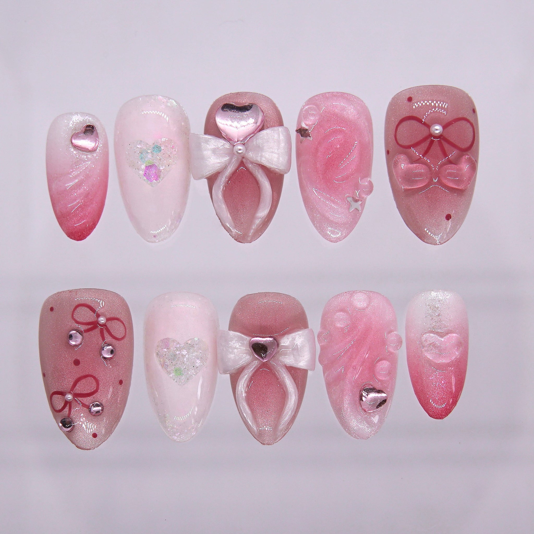 Room 328, La Valencia press-on nails featuring pink-to-white gradient, 3D sculpted bows, glitter hearts, and floral carvings — part of the La Jolla · Wood · Bloom collection.
