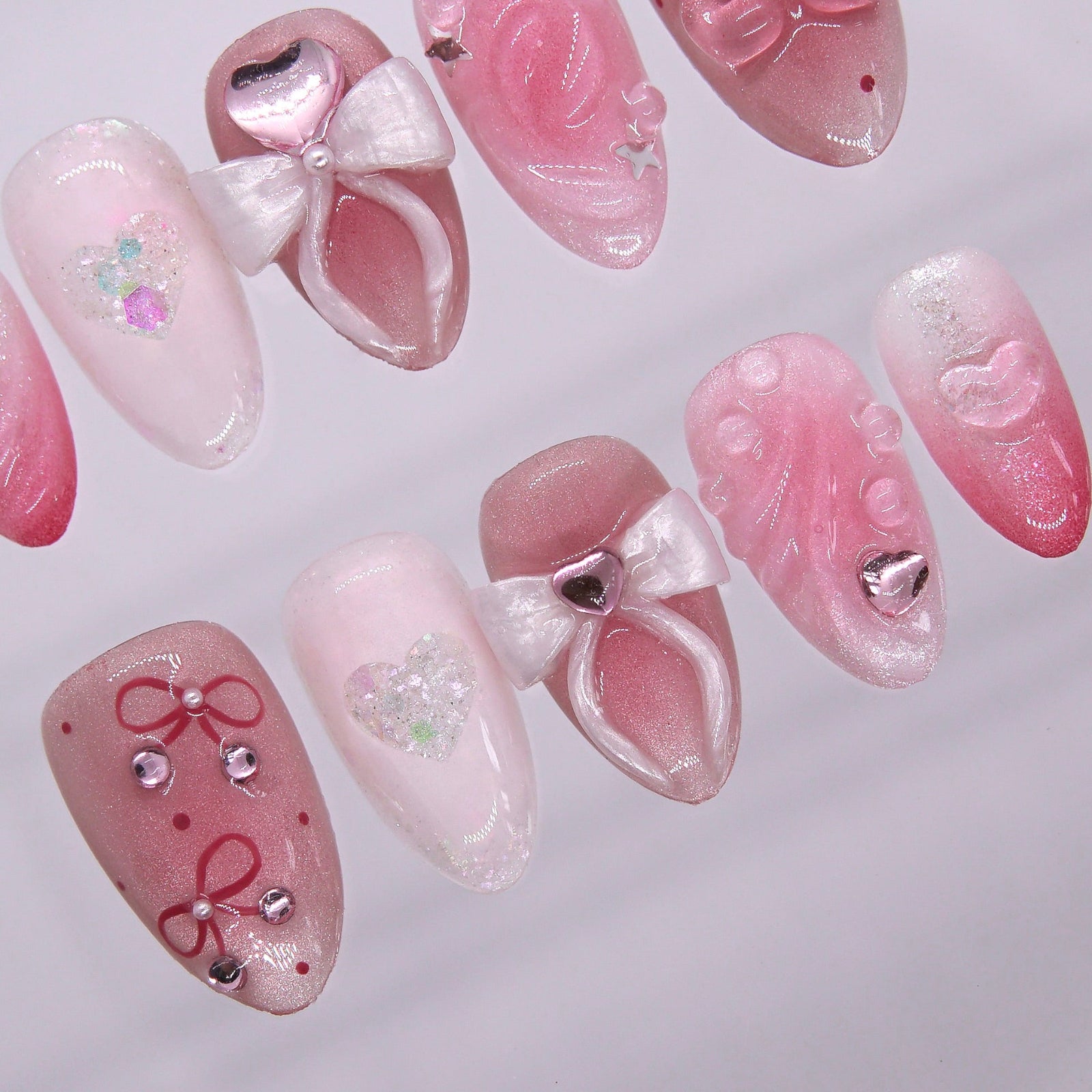 Macro detail of soft pink ombré base with hand-sculpted floral swirls and embedded stars and pearls.
